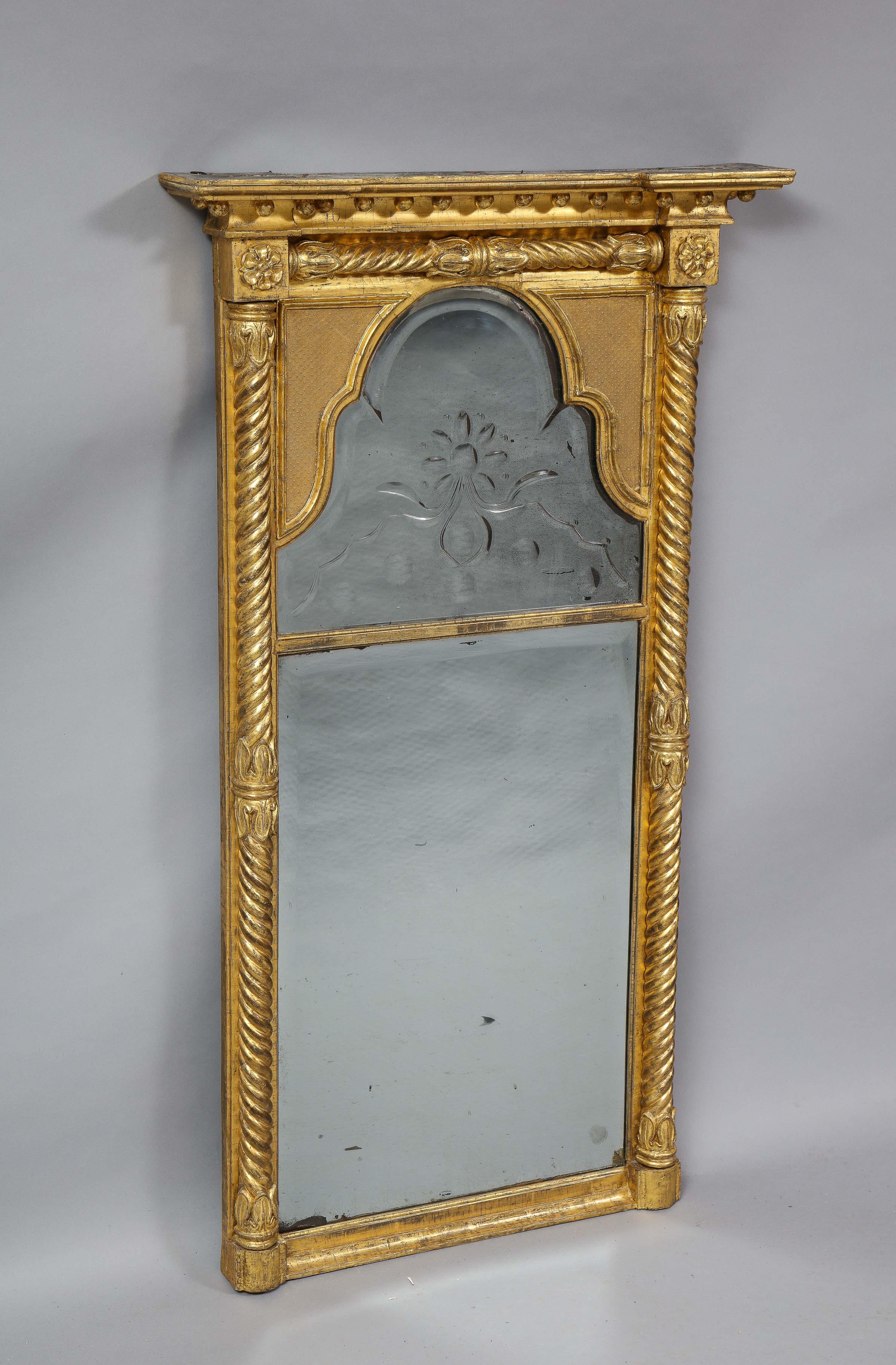 Most unusual early 19th century giltwood pier mirror, the crest with a row of suspended gilt balls, over an arched, etched and hollow beveled Vauxhall mercury glass upper and lower plate, surmounted with spiraled gilt columns, the whole retaining
