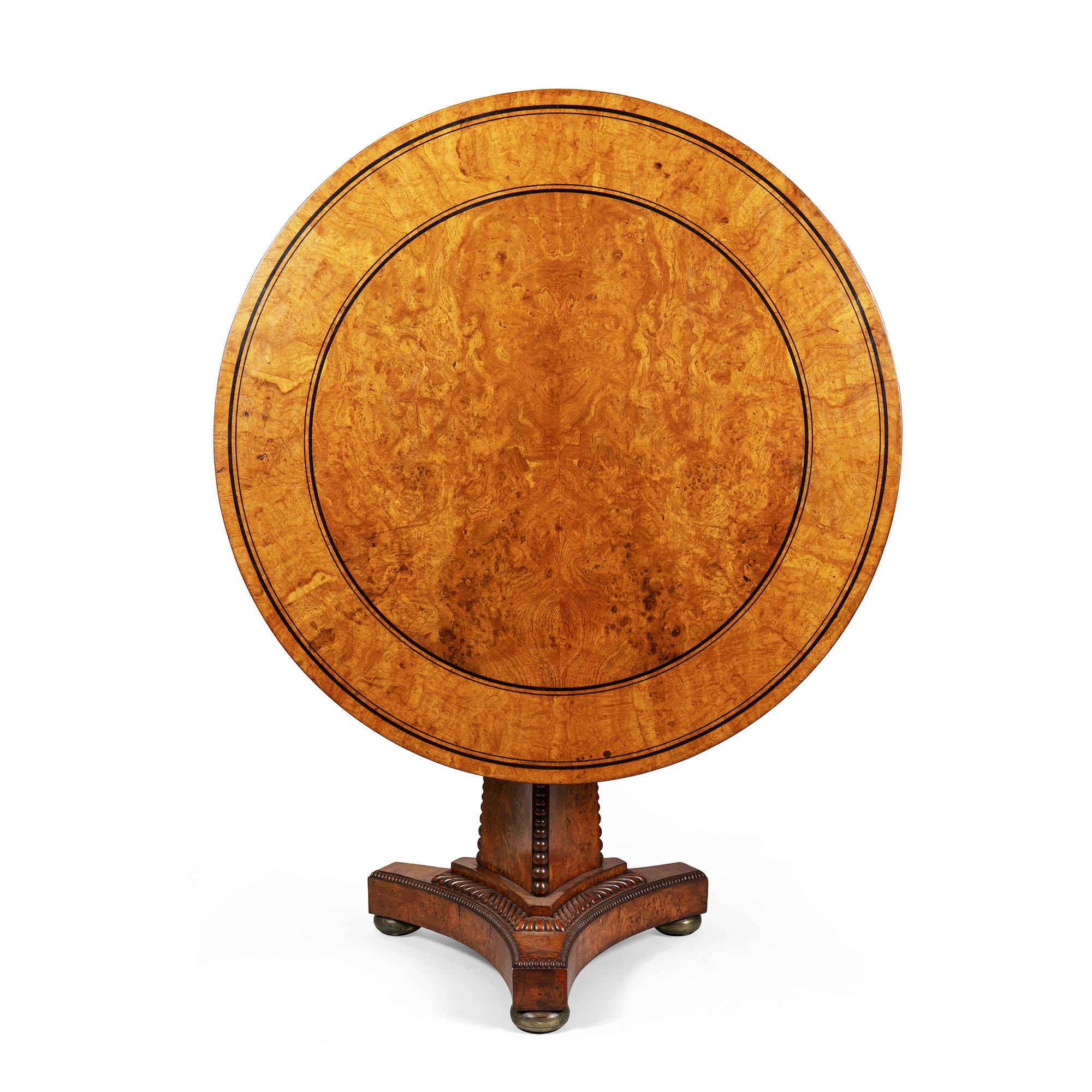 The circular top with a central panel of bookmatched pollard oak boarded with ebony banding and feathered pollard oak laid at right angles. The whole raised on a pedestal base with concave sides and detailed with graduated half balls, the concave