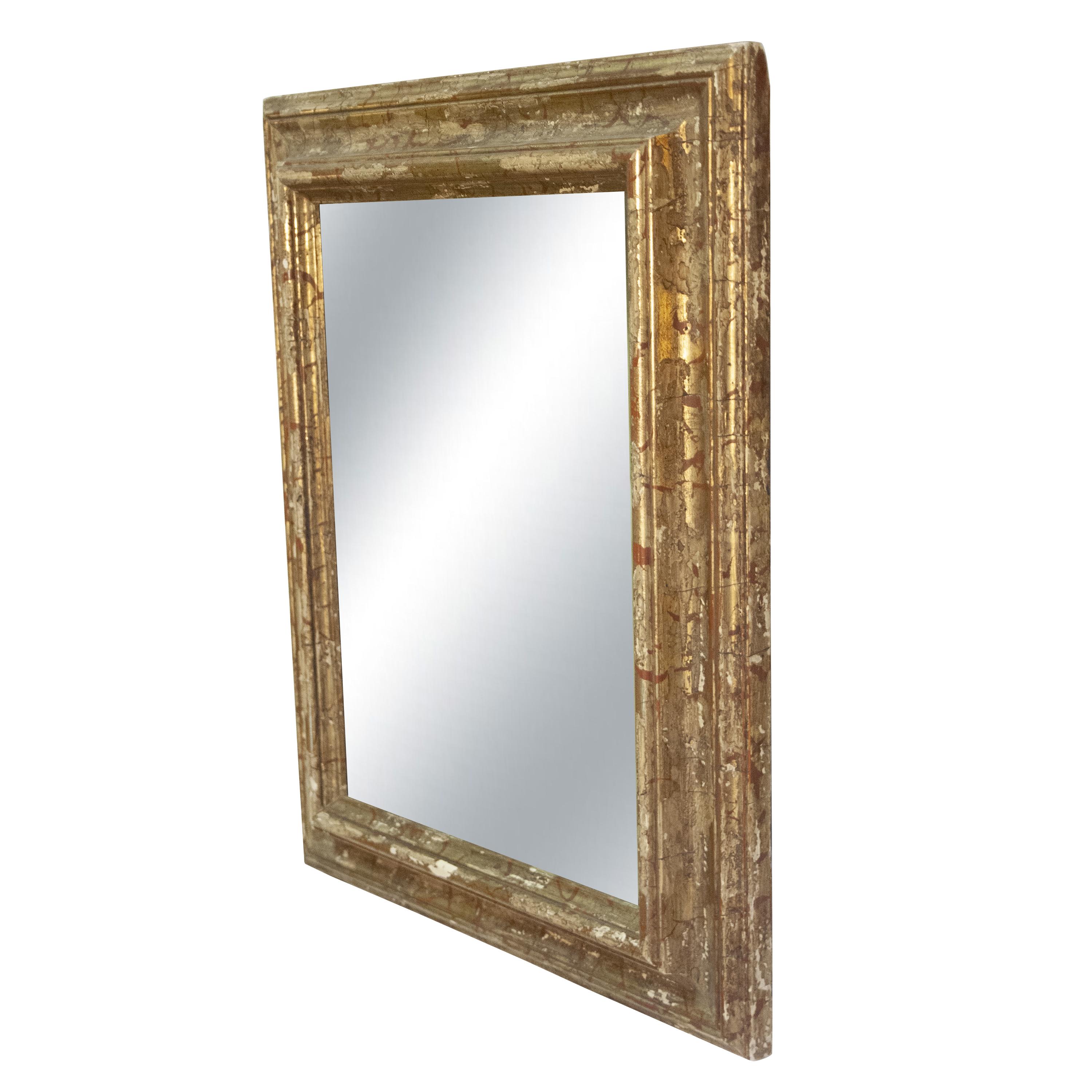 Handcrafted carved Regency style wood mirror covered in gold foil.