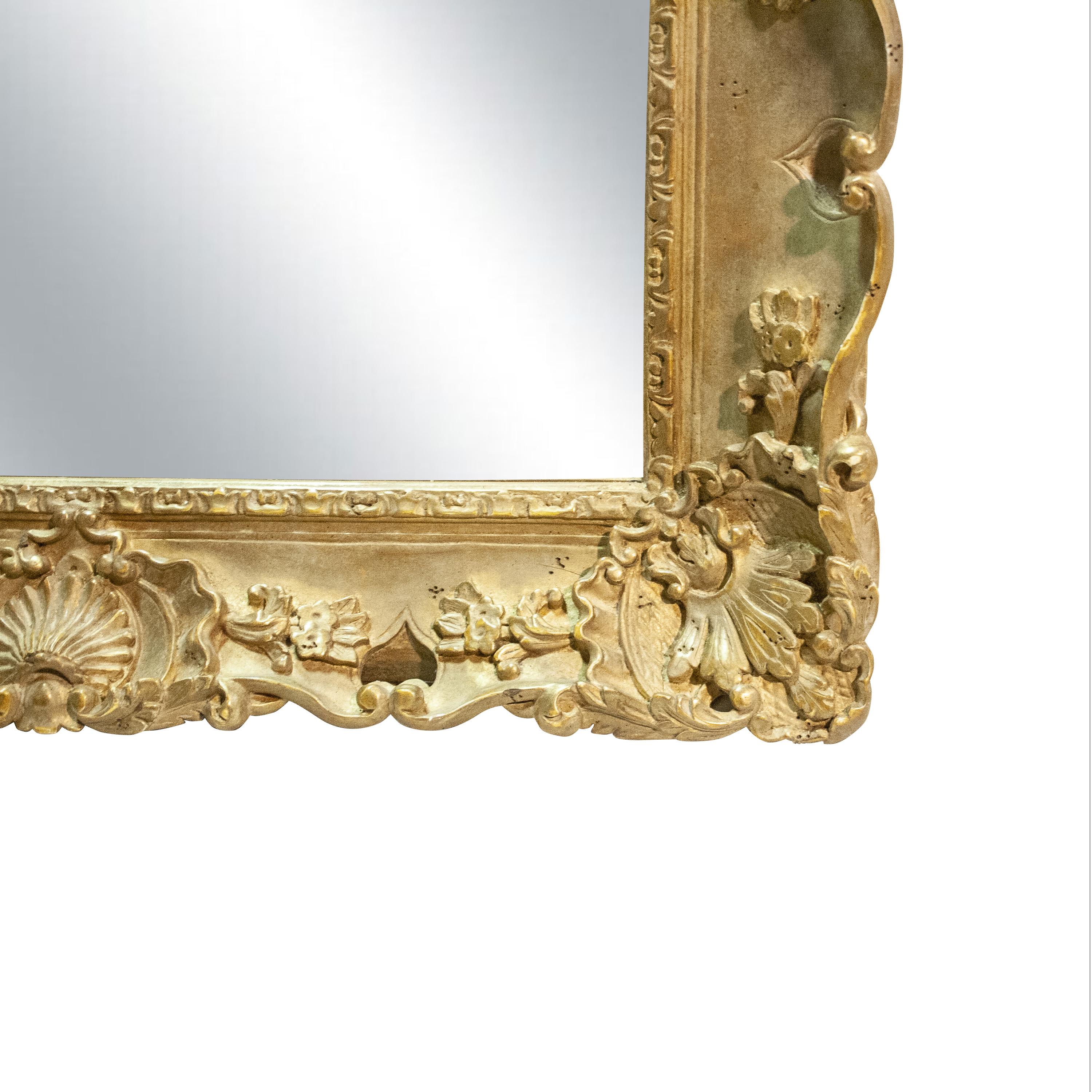 Handcrafted carved Regency Style wood mirror covered in gold foil.