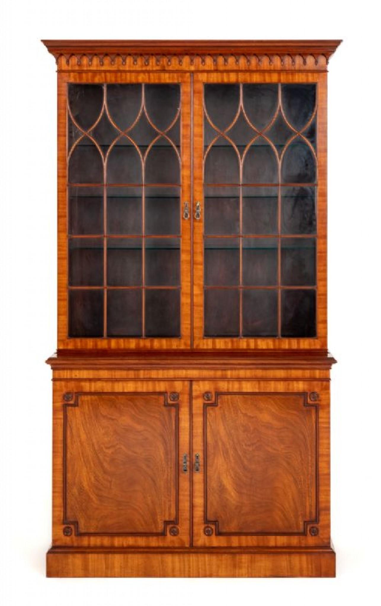 Regency Revival mahogany glazed library bookcase.
This bookcase stands upon a plinth base.
The 2 lower doors being of a panelled form with wonderful lame mahogany timbers and feature architectural moldings and turned roundels.
The up[per section