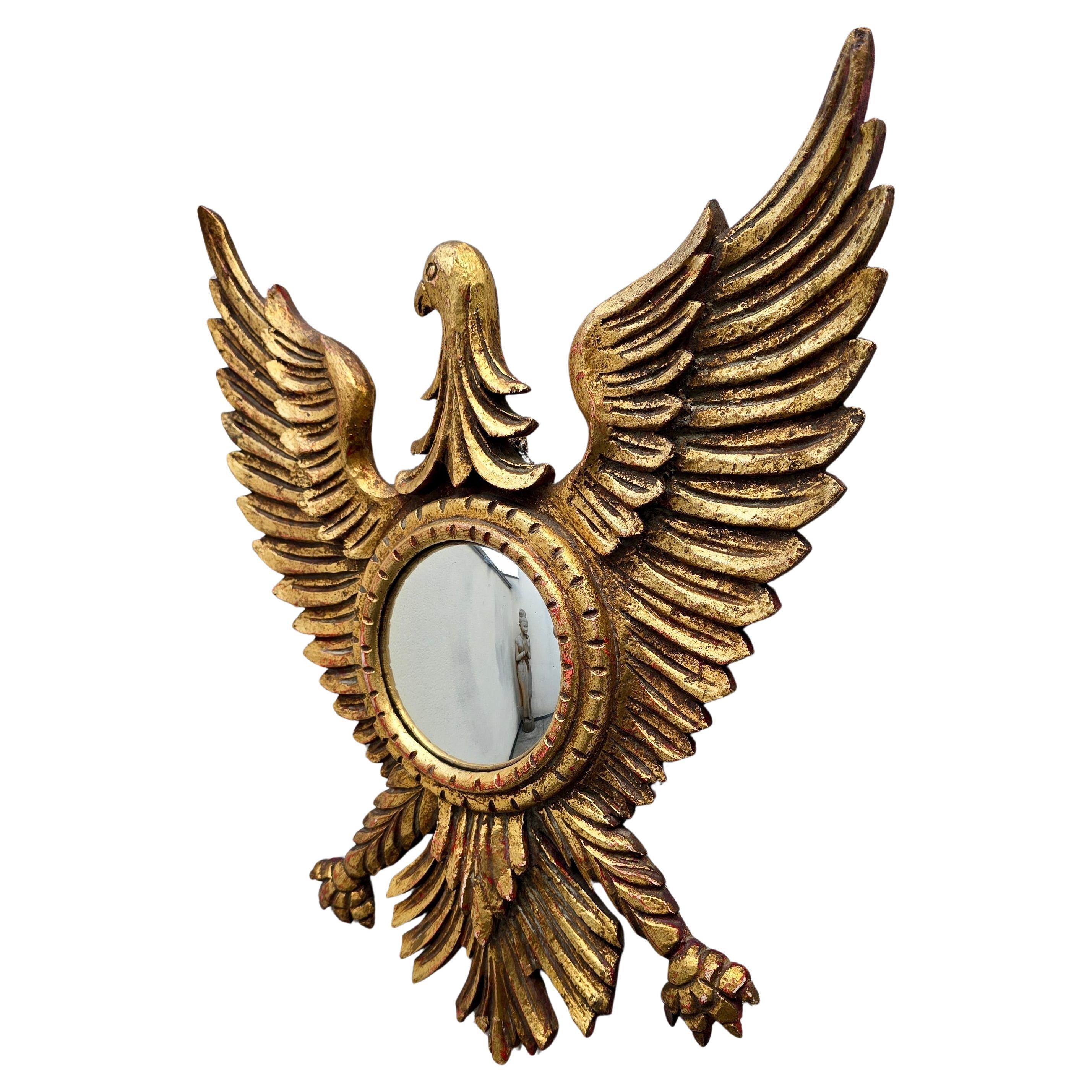 Specchio convesso Aquila in legno dorato Regency Revival, anni '50

Specchio decorativo convesso a forma di aquila ad ali spiegate, risalente alla metà del XX secolo. Realizzato in legno pressato con finitura dorata su base rossa, per un caldo