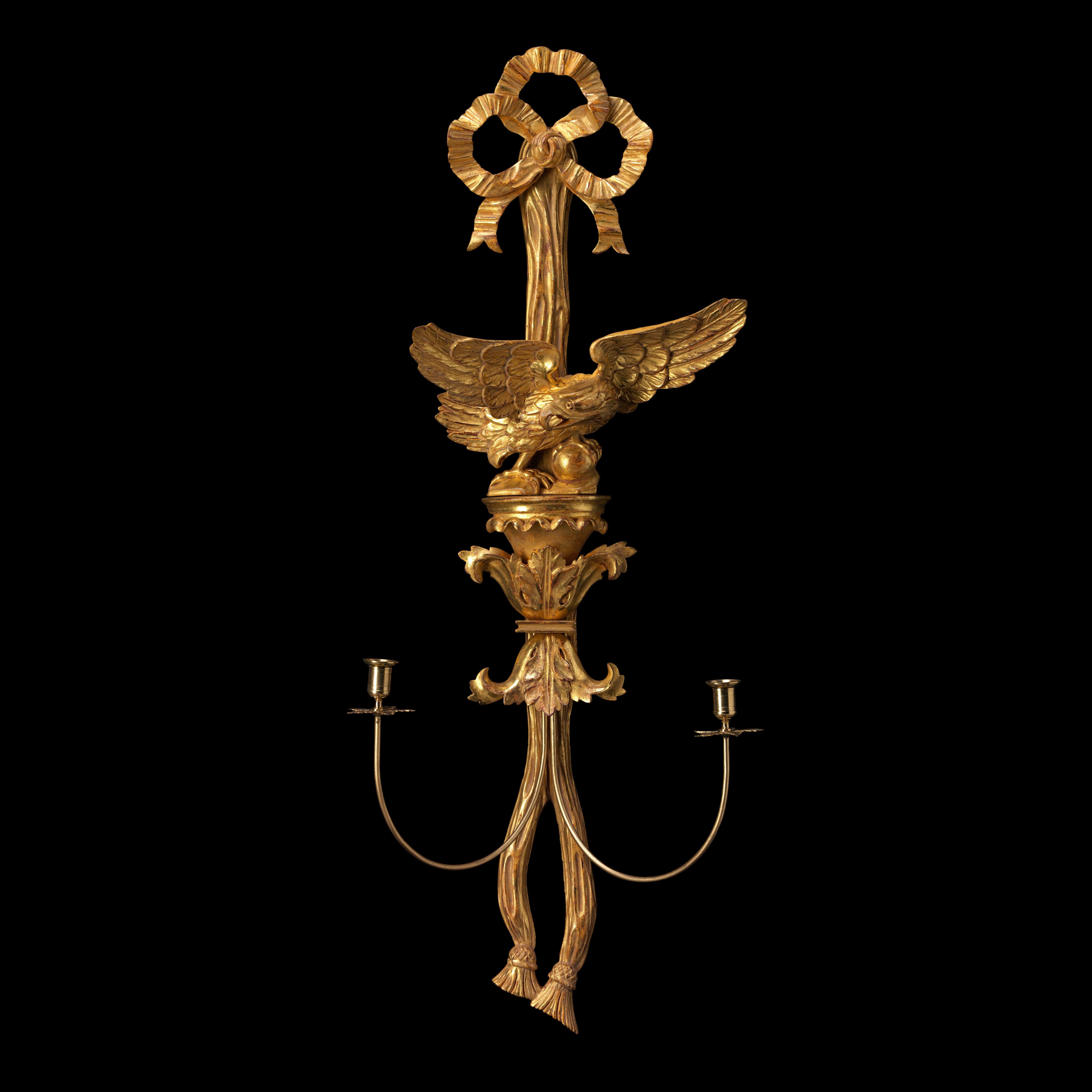A Regency design carved gilded wood wall light in the form of a splayed eagle standing on acanthus brackets, supported by stylised ribbons.

Bespoke sizing, design adaptations and finishing available.

We are currently working to a 30-36 week