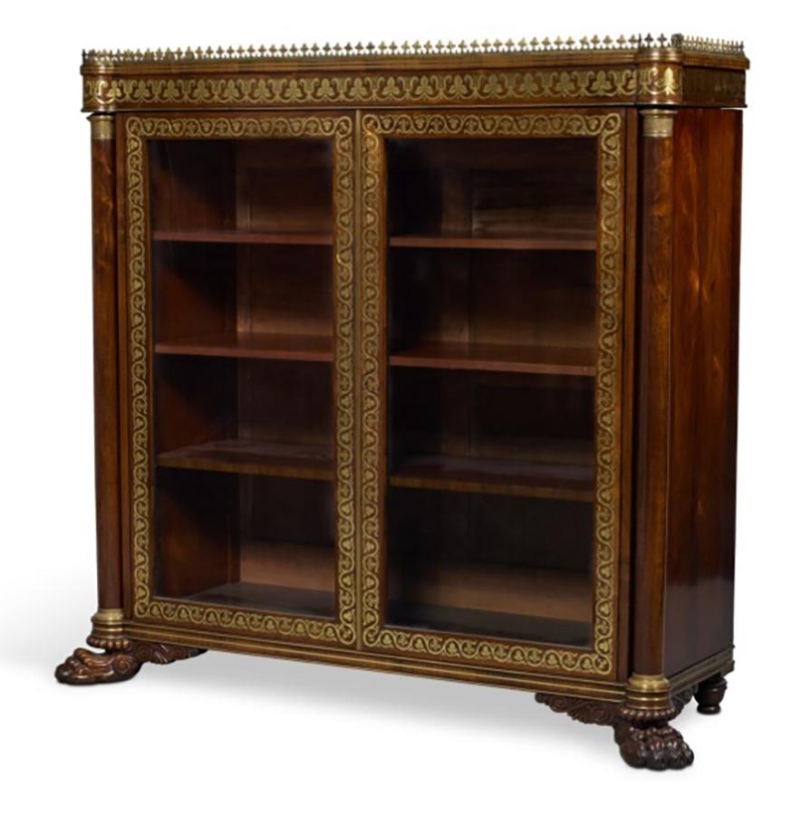 Rectangular finished top with brass gallery over a brass inlaid frieze and a pair of brass inlaid glazed doors enclosing shelves. Raised on lions paw feet. Sold Christies, New York April 9th 2003 lot 135.