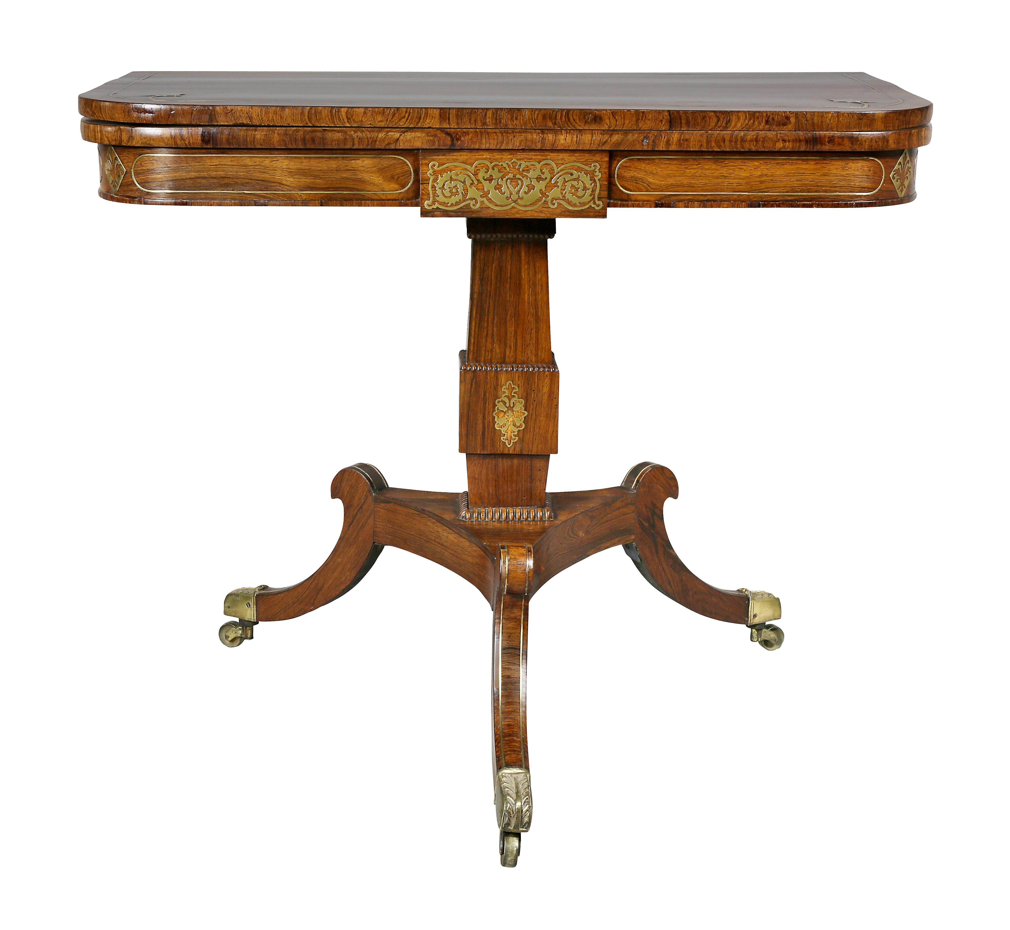 Rectangular hinged top opening to a rosewood playing surface, brass inlaid central panelled frieze with overall stringing, square section support ending on three saber legs and casters.
