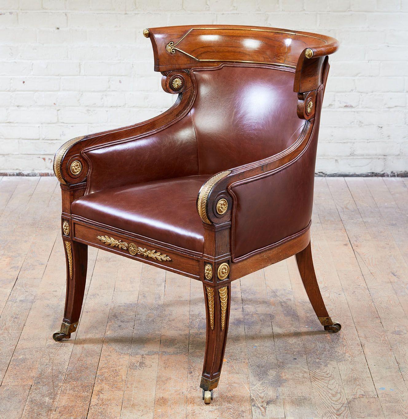 Fine Regency rosewood and gilt brass armchair in the manner of Morel and Hughes, having curved back with gilt brass mounts over scrolled arms with gilt longleaf mounts, over scrolled legs having gilt roundels and gilt money in tapering form down the