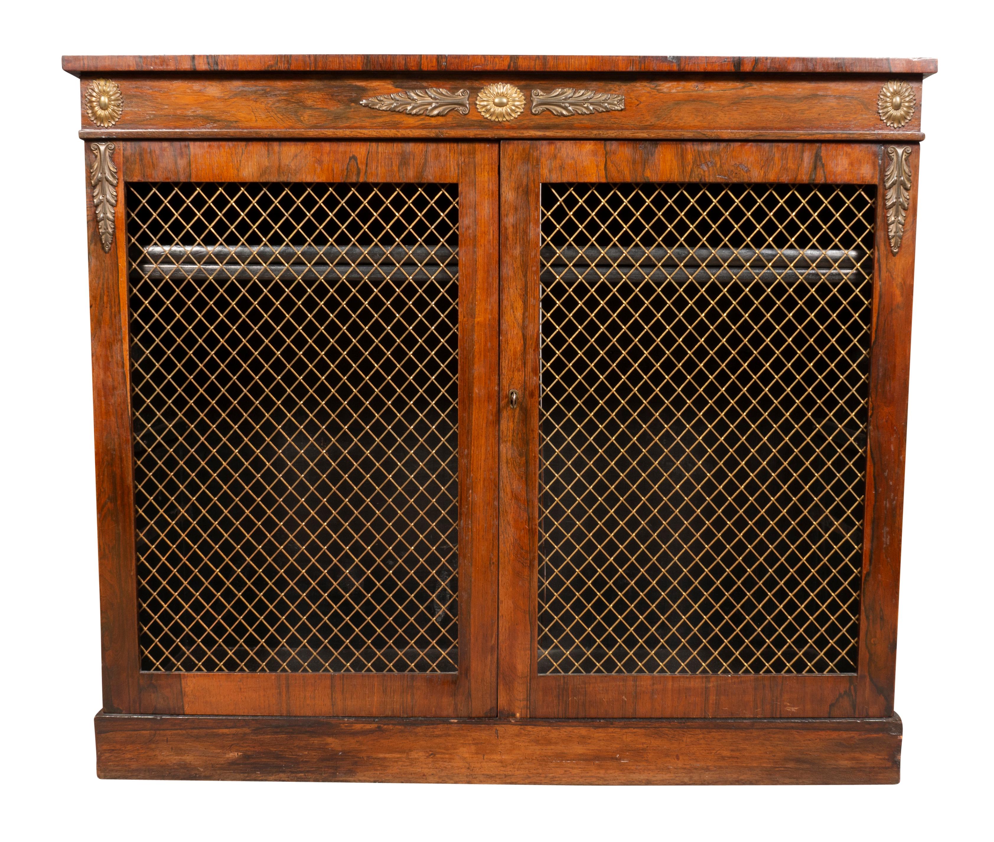 Rectangular top with short back board over a frieze with brass mounts and a pair of grill doors enclosing two shelves. Plinth base.