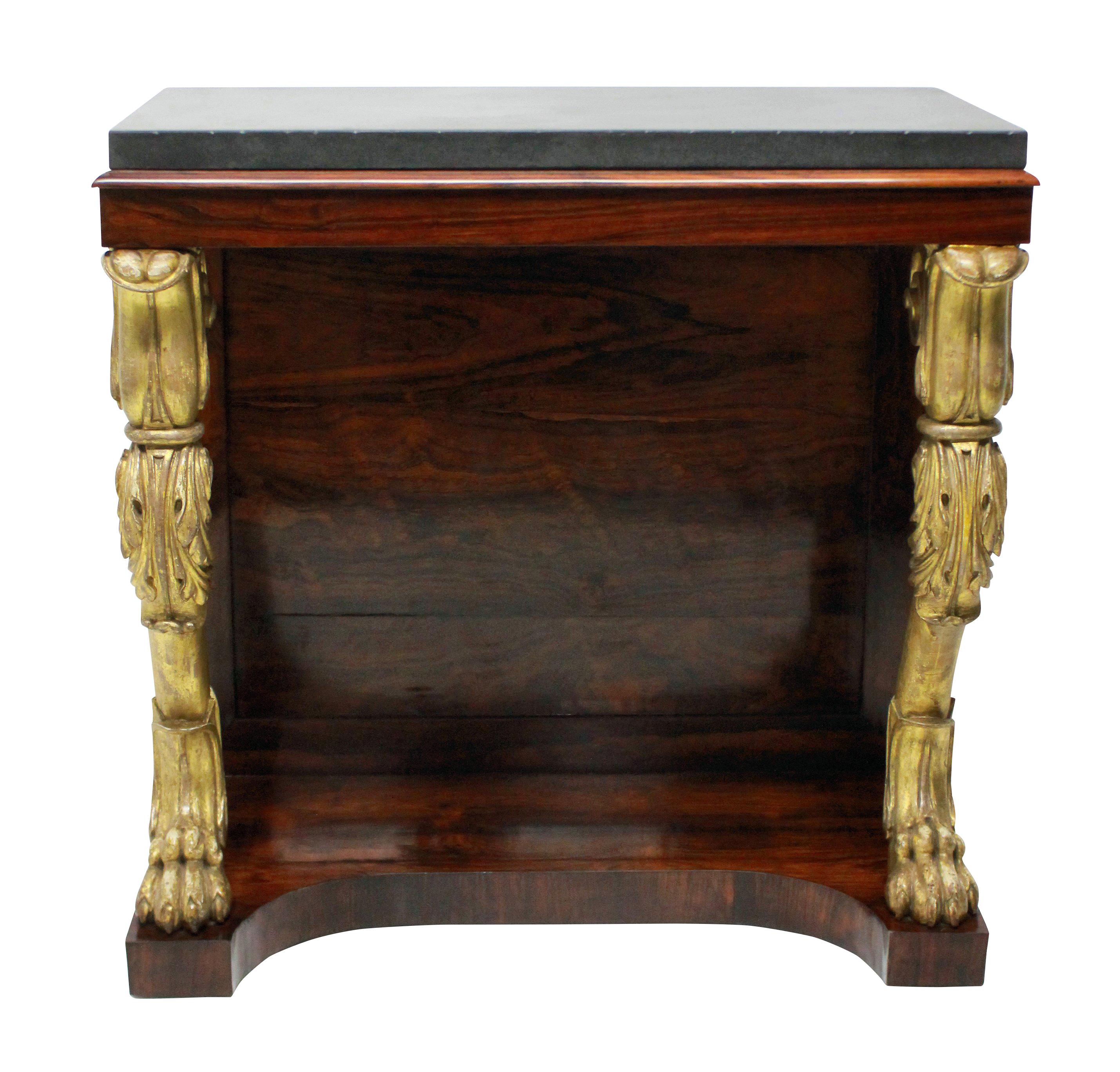 An English Regency console table in rosewood, with two carved and water gilded monopodia legs. The top of Belgian marble.

   
    