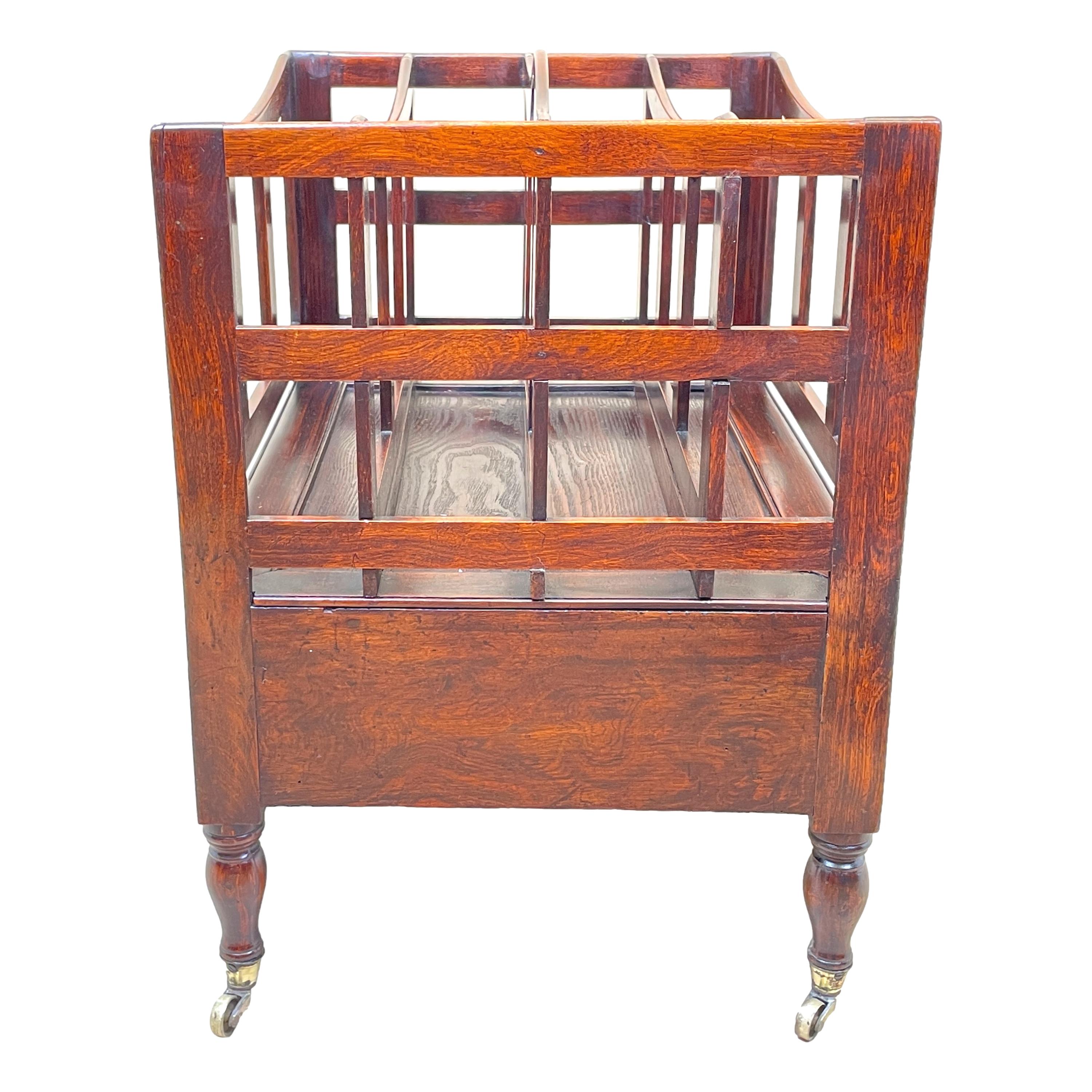 An early 19th century regency period simulated rosewood boat shaped Canterbury, having pierced carrying handle and divisions, over one frieze drawer with later brass handle, raised on elegant turned legs with original brass castors. 

This unusual