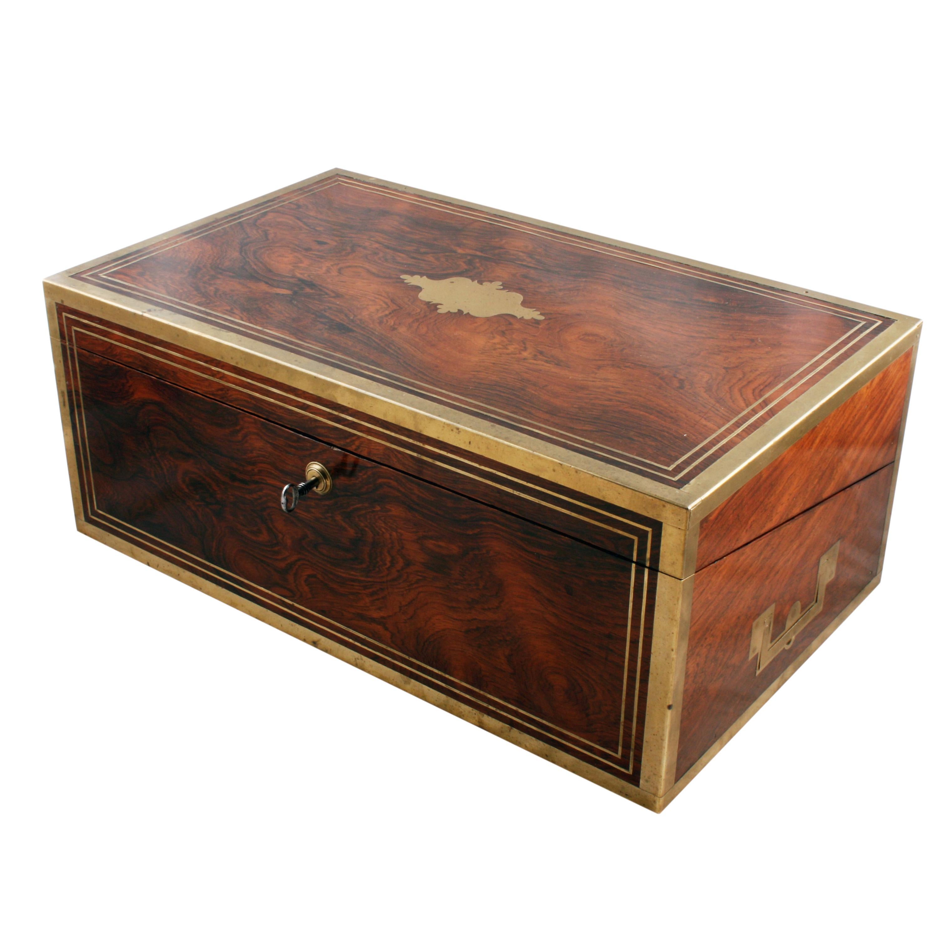 A fine early 19th century Regency brass bound rosewood box desk.

The box is made of good quality mahogany and rosewood veneers with brass bound corners, line inlays and the brass lock is stamped 'J Bramah Piccadilly' and a crown.

The box has a
