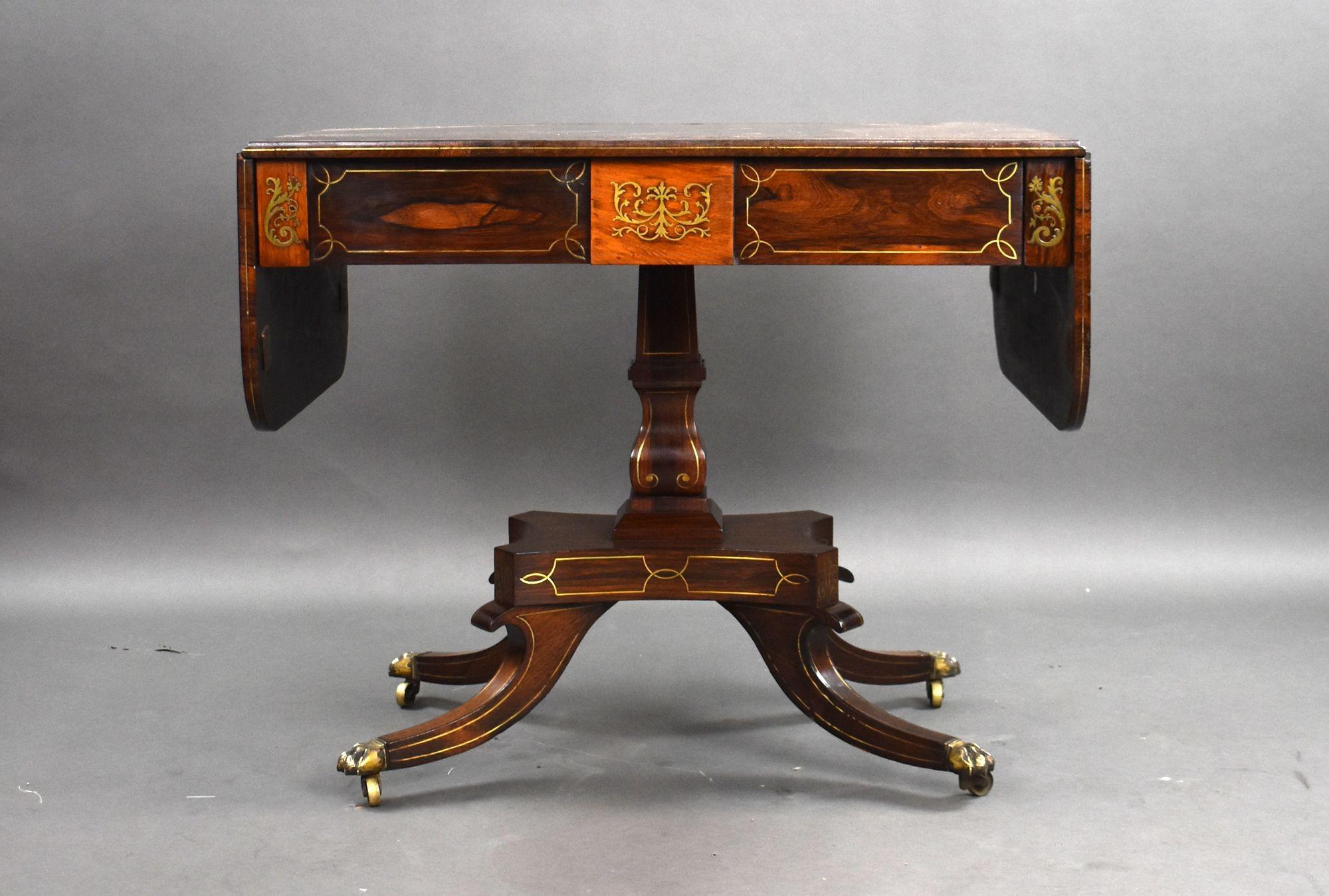 Il s'agit d'une superbe table de canapé de style Regency en marqueterie de laiton. Le plateau en palissandre richement figuré est abondamment incrusté de laiton, il est surmonté d'un tiroir unique à l'avant à côté d'un faux tiroir, sur le côté
