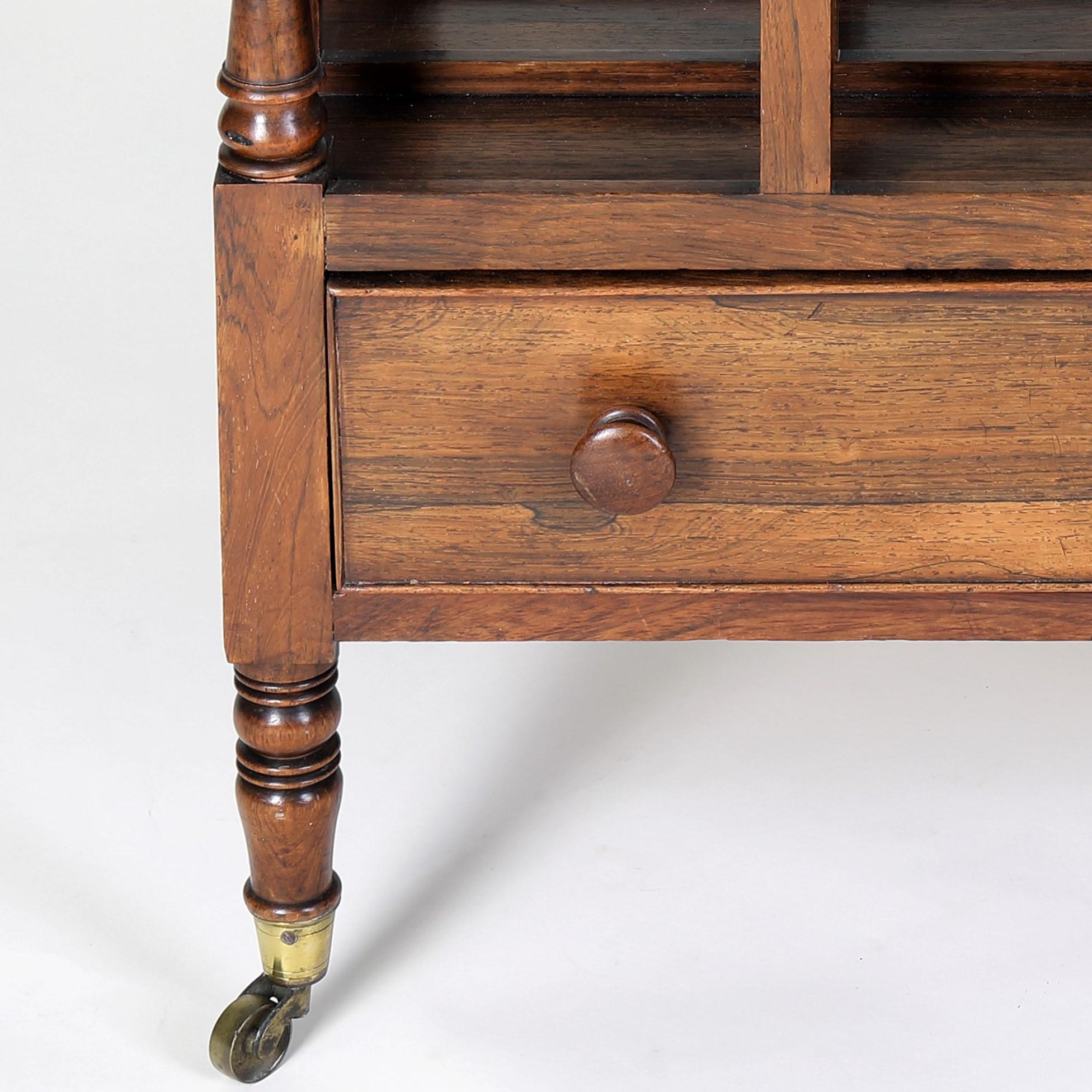 A very fine quality Regency period rosewood Canterbury of classic shape and form with four divisions and a central carrying handle above a drawer and raised on elegant turned legs.
A particularly smart version in superb condition for it's age.