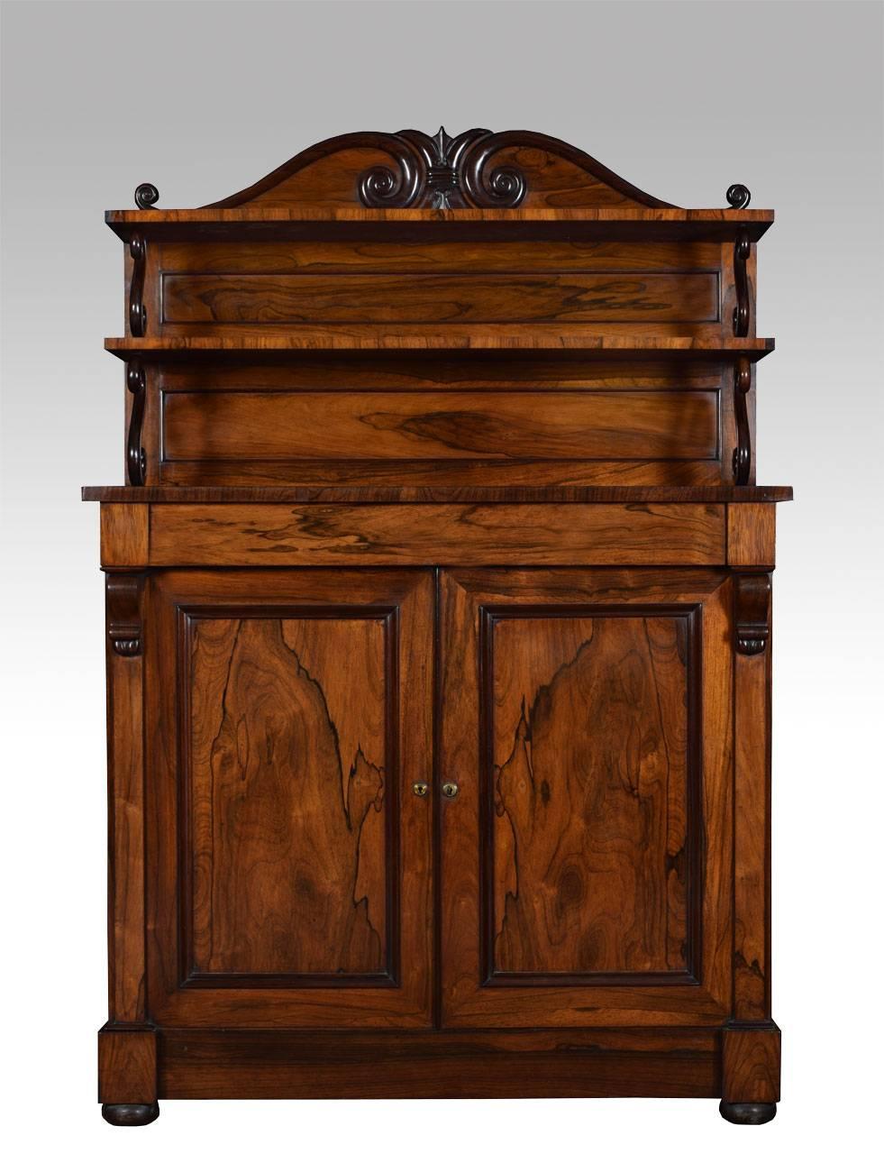 Regency chiffonier, the raised panelled gallery back with S scroll brackets. The base section with single draw above two rosewood panelled cabinet doors enclosing two adjustable shelves, on plinth base terminating in bun feet

Dimensions:

Height 66