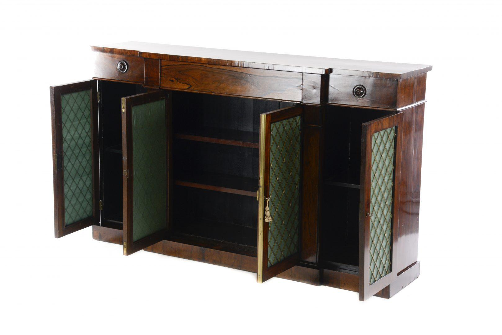 A very good quality Regency rosewood credenza, the breakfront top above a central drawer and four cupboards with metal lattice and silk backing on a plinth base.
