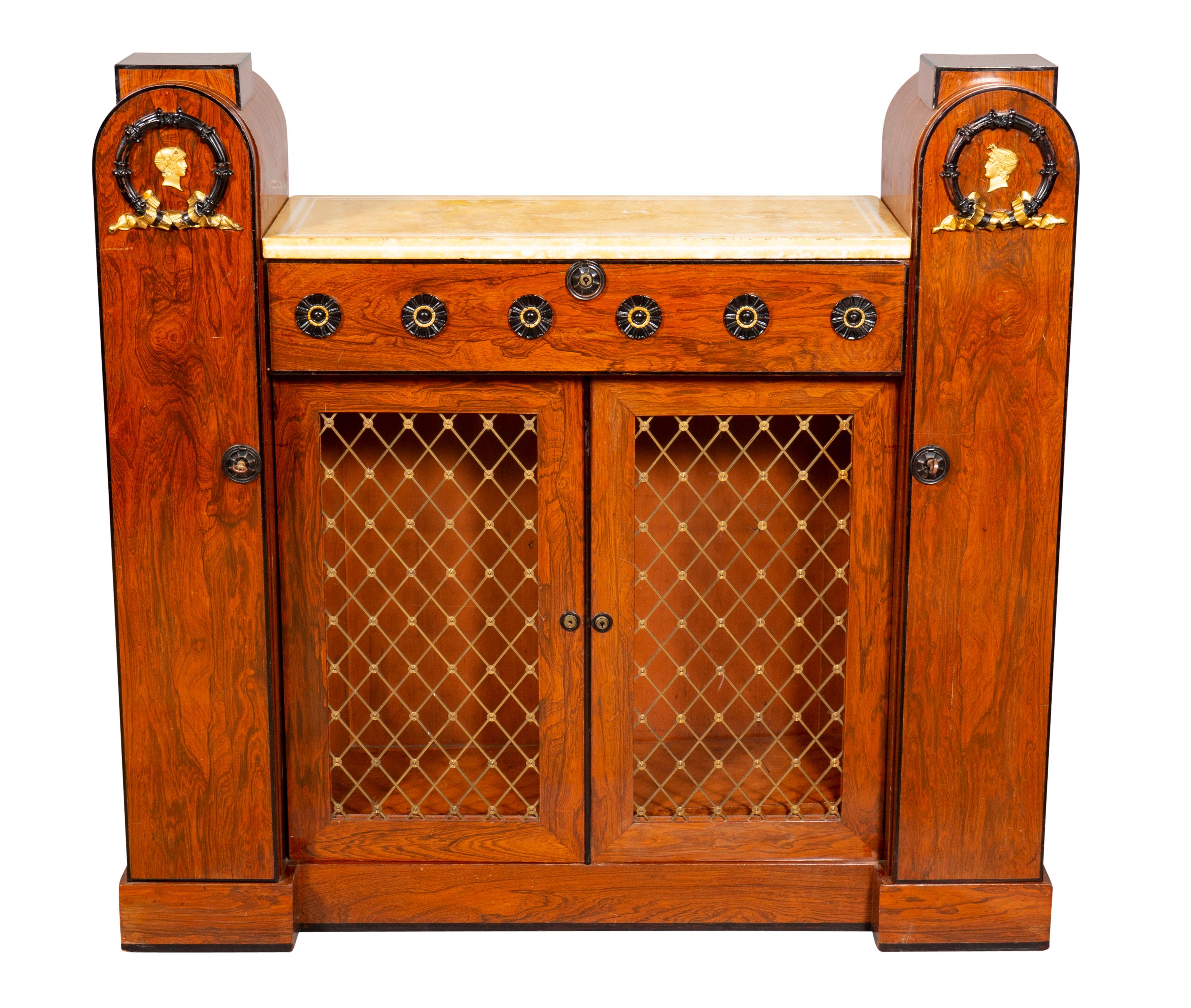 Unusual form originally having a backboard. With marble top with raised arched ends with bronze wreaths and mask over a long drawer and pair of grill doors flanked by cabinet doors. Plinth base.