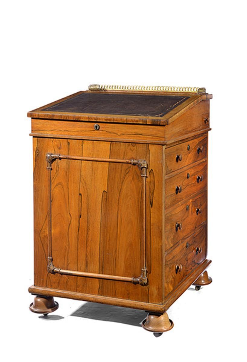 A Regency rosewood davenport, the sliding top in the manner of Gillows and a brass gallery to the back.
To the left side are four graduated drawers, each furnished with a pair of rosewood pulls, and to the right, four dummy drawers plus a small pen