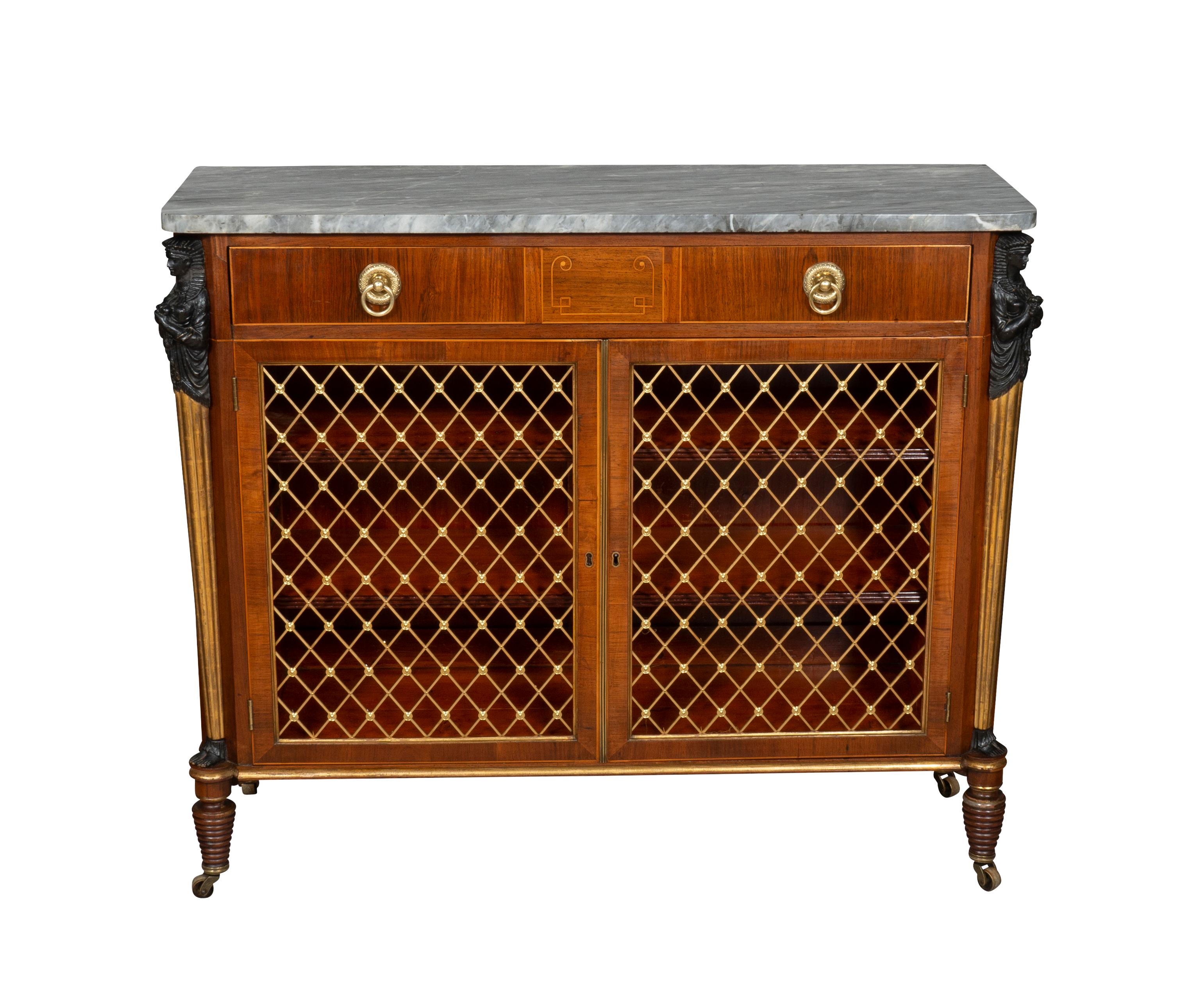 A good example with rectangular original grey and white marble top over a drawer with central geometric string inlay and two brass ring handles over a pair of grill doors flanked by ebonized and water gilded Egyptian caryatids , the ends with grill