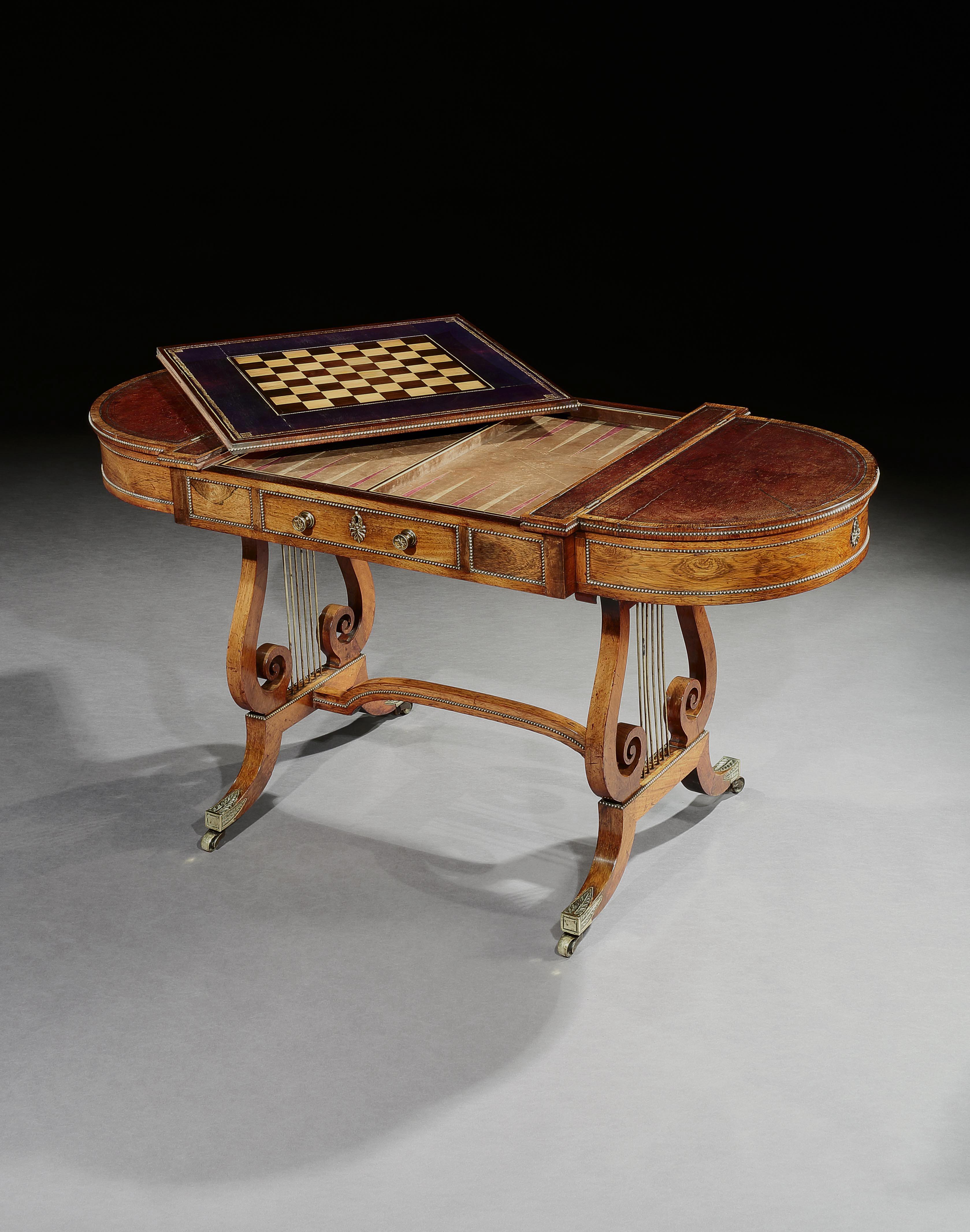 A elegant George III rosewood sofa backgammon table, the leather lined top with rounded ends opening for the storage of chess and backgammon pieces, the centre section having a reversible top with an inlaid chess board to the underside, which