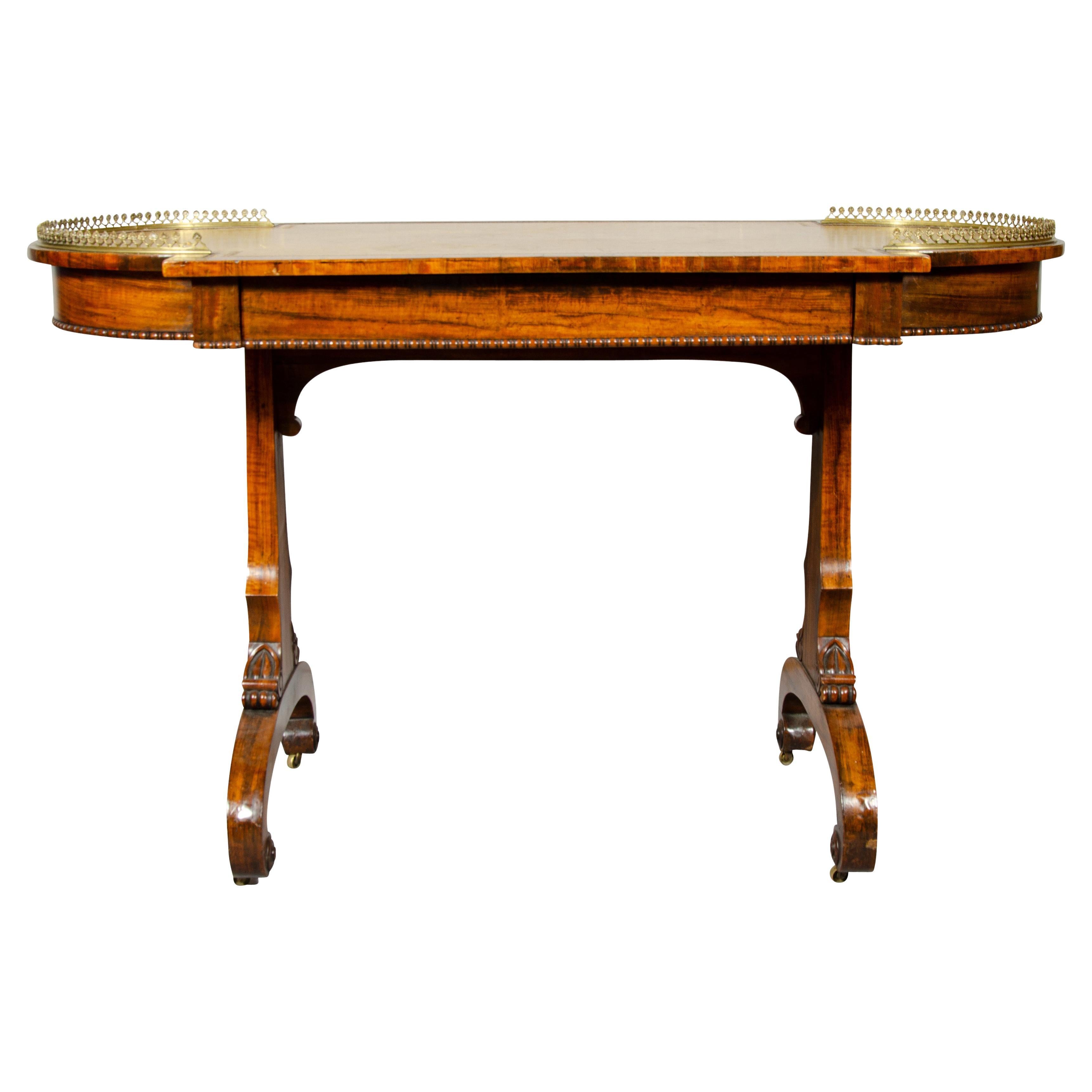 With rectangular top with rounded ends, brass gallery and inset tooled leather top, frieze drawer, beaded base of frieze, trestle base, scroll carved legs.
