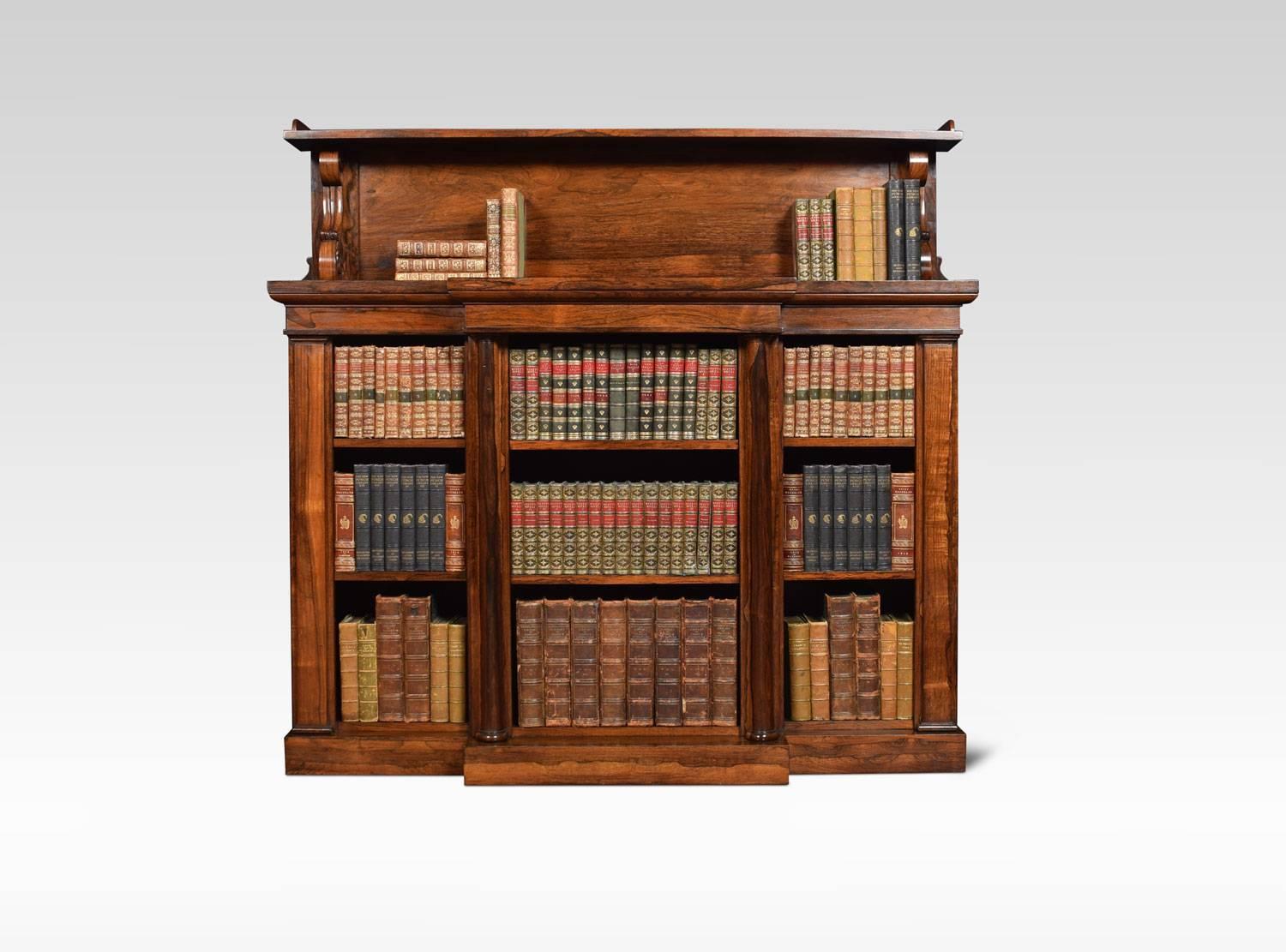 Regency rosewood bookcase the raised gallery supported on scroll supports, to the large breakfront top with moulded edge. Above three bays of adjustable shelves. All raised up on plinth base.

John Kendall was a cabinet maker from Leeds, Yorkshire