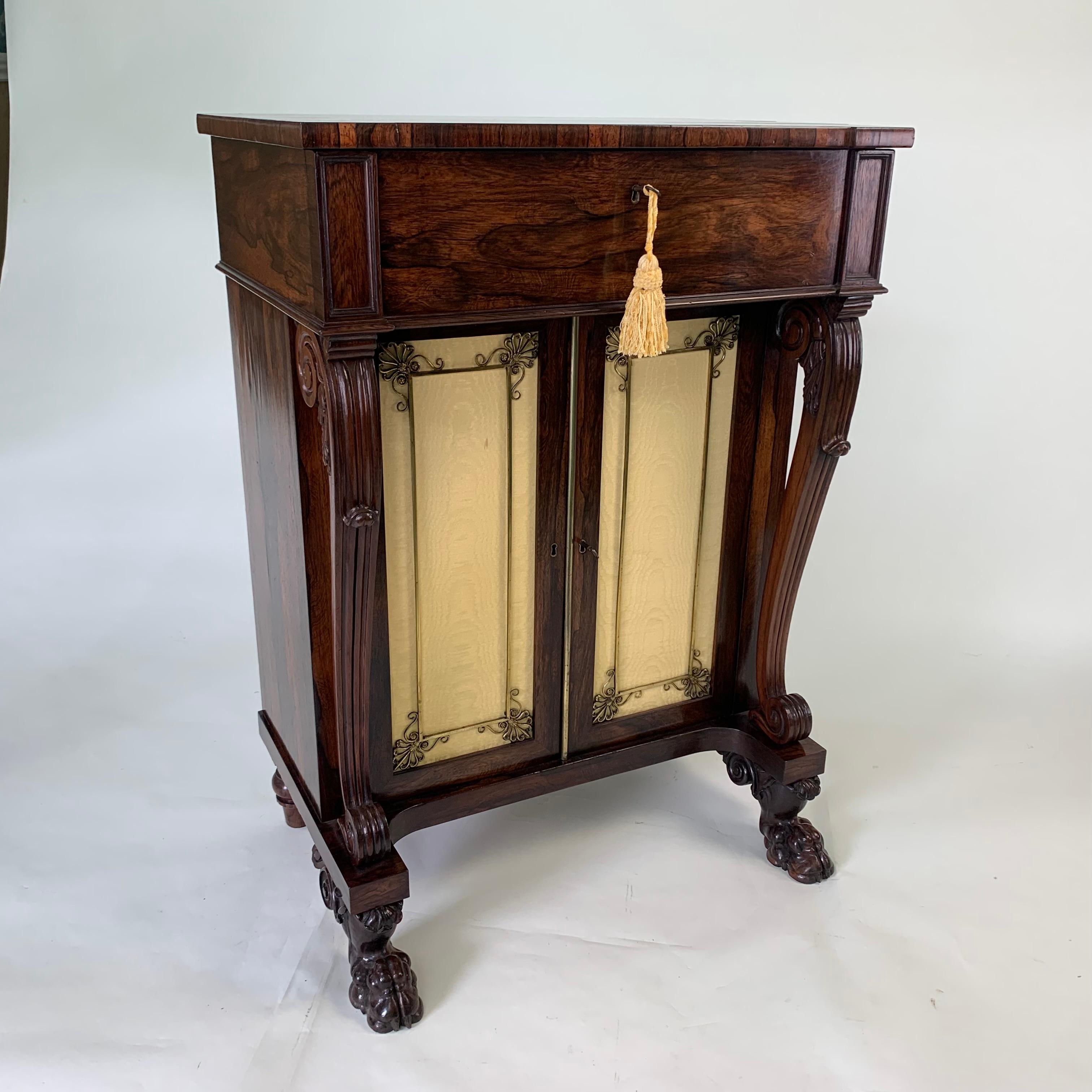 A superior quality and unusual Regency rosewood Side Cabinet, the top drawer with fold-down, leather-lined front, fully fitted with drawers and pigeon holes. below are a pair of silk-lined cupboard doors with original and elaborate brass grills.