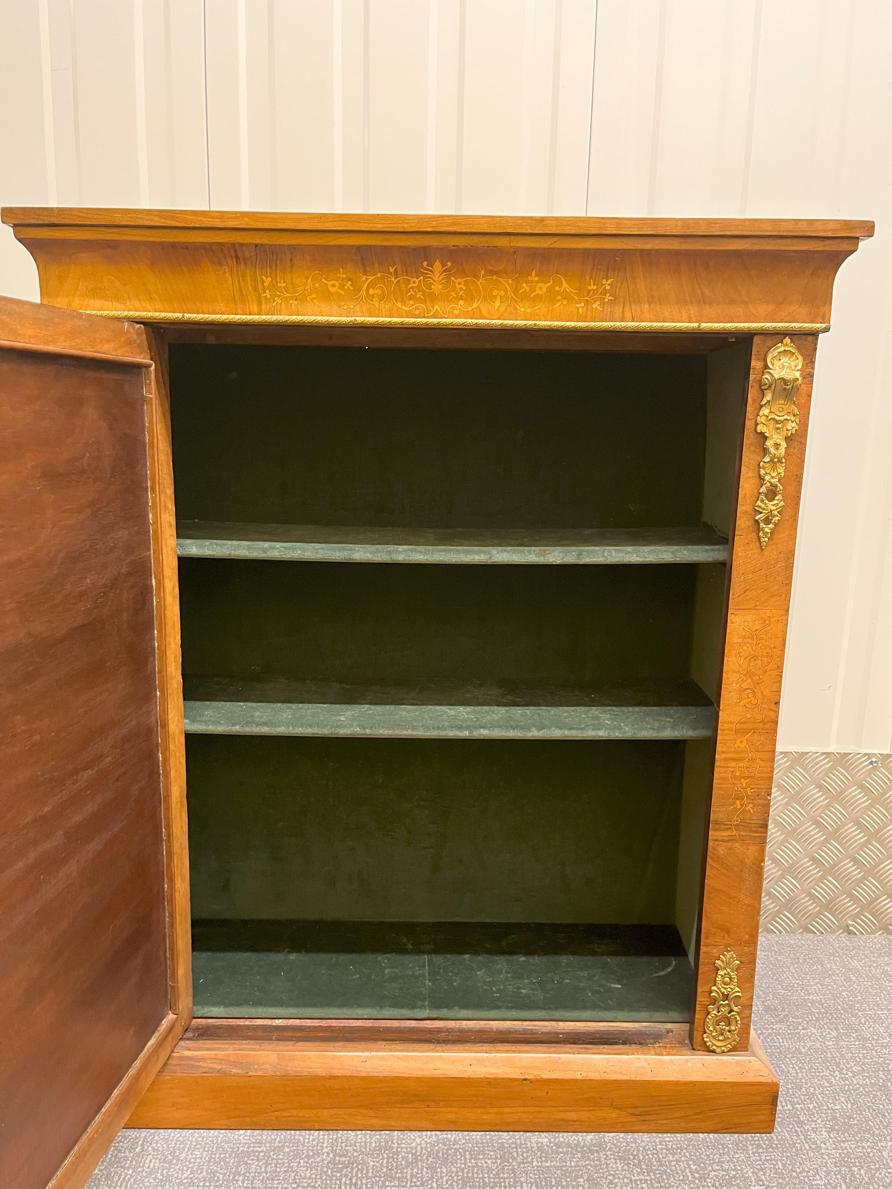 An attractive Regency rosewood side cabinet with inlaid decoration on and above the door and brass furniture.   