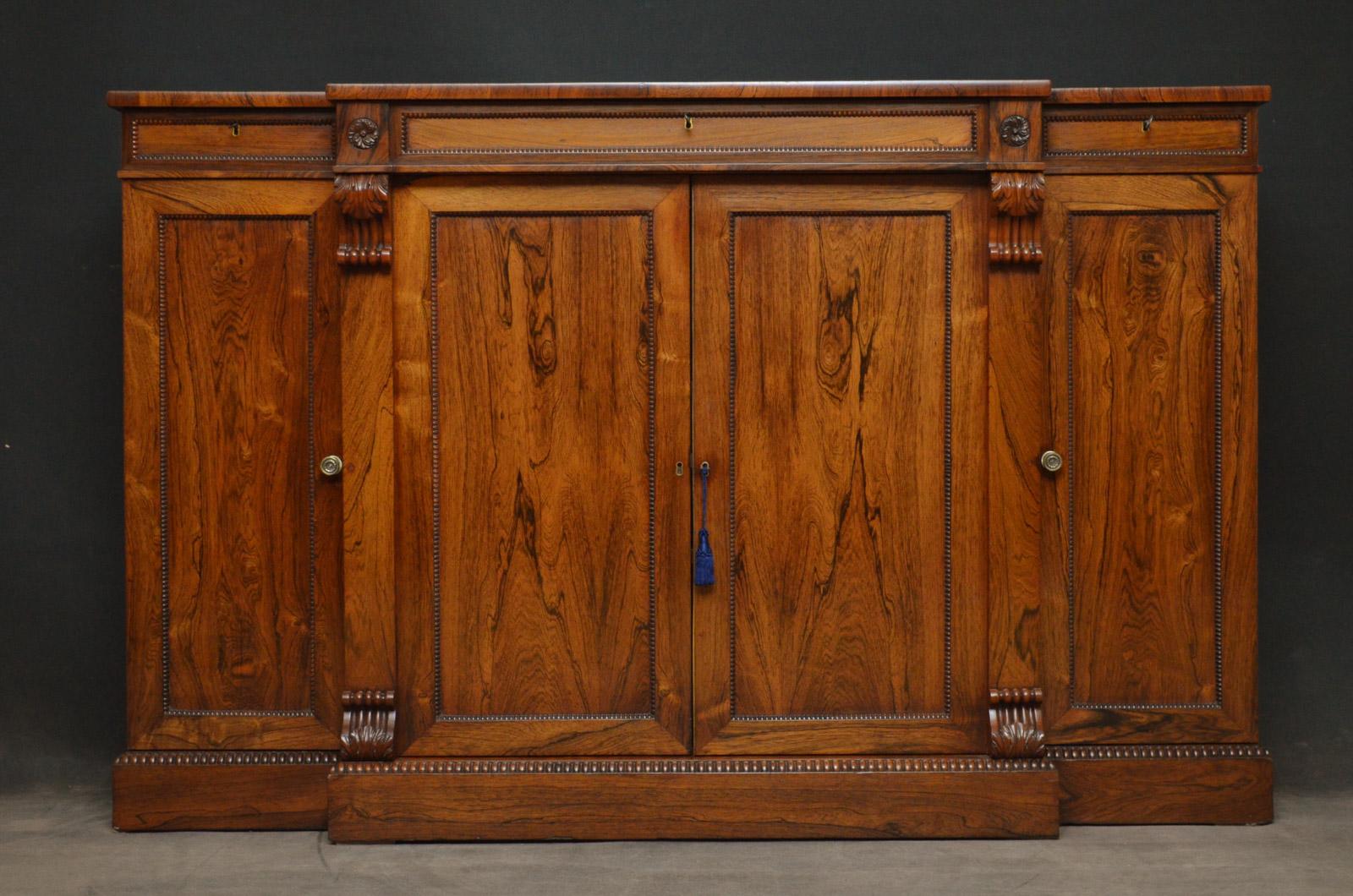 Sn4375, fine quality and very elegant Regency four door, breakfronted sideboard in rosewood, having attractive top above three mahogany lined drawers flanked by flower pateras, and a pair of projecting panelled doors flanked by finest quality drop