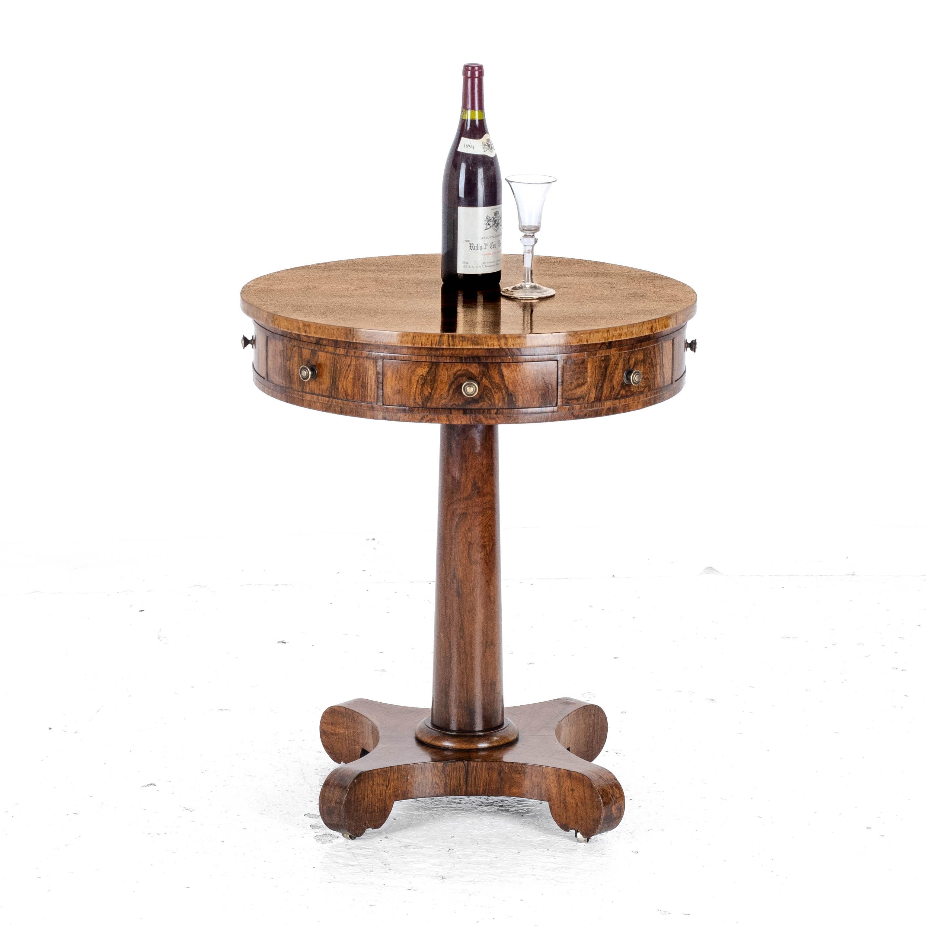 A Regency period, rosewood small drum table with drawers, circa 1825. With circular top and banded edge, frieze with 4 drawers interspaced with 4 faux drawer fronts. All with brass knob handles. Tapered plain turned column support, on a quadform
