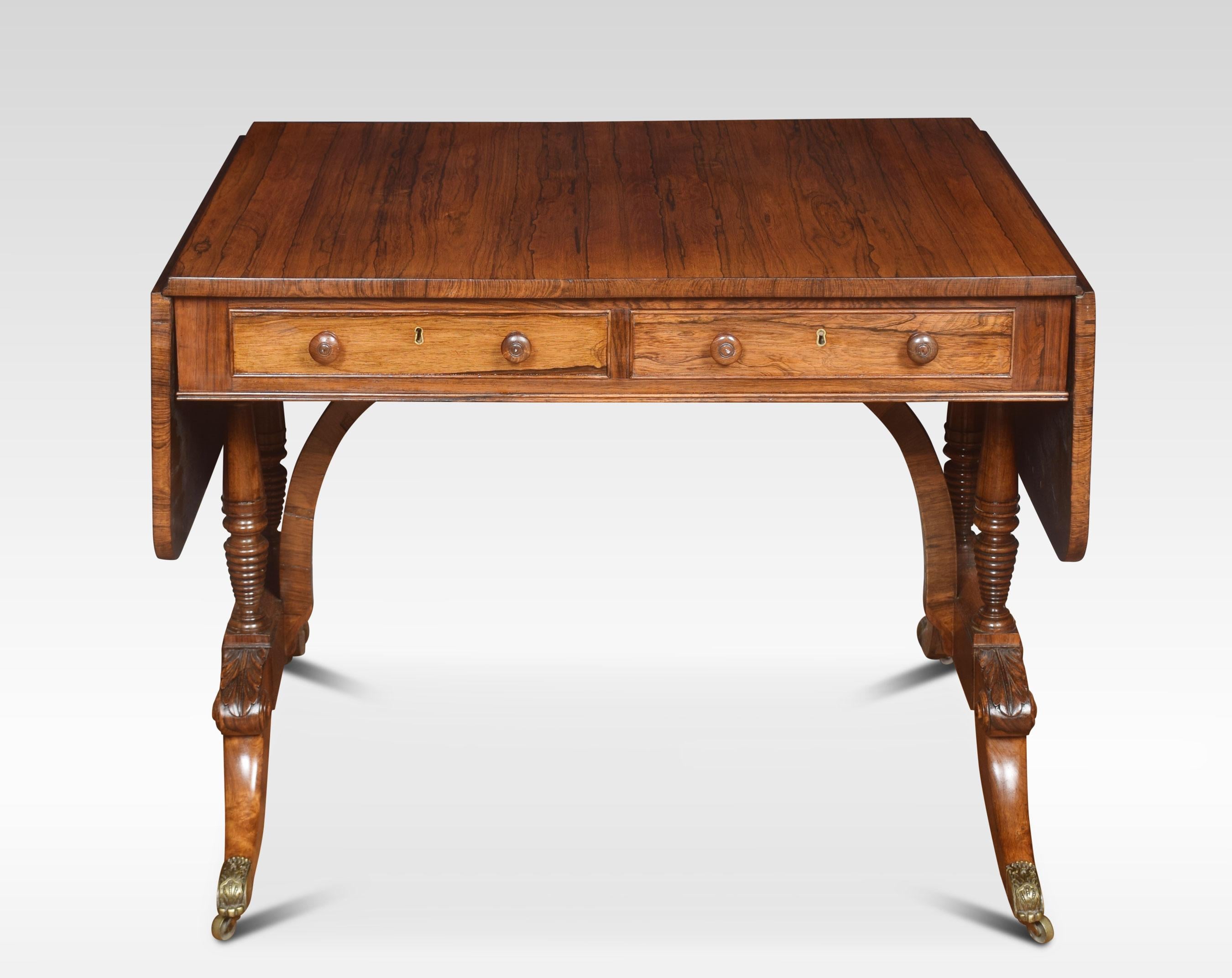 Regency rosewood sofa table, the rectangular top, and two drop leaves, two freeze drawers the opposing side having dummy drawers. Raised up on ring turned supports and out swept legs with brass terminals and castors.
Dimensions:
Height 28.5