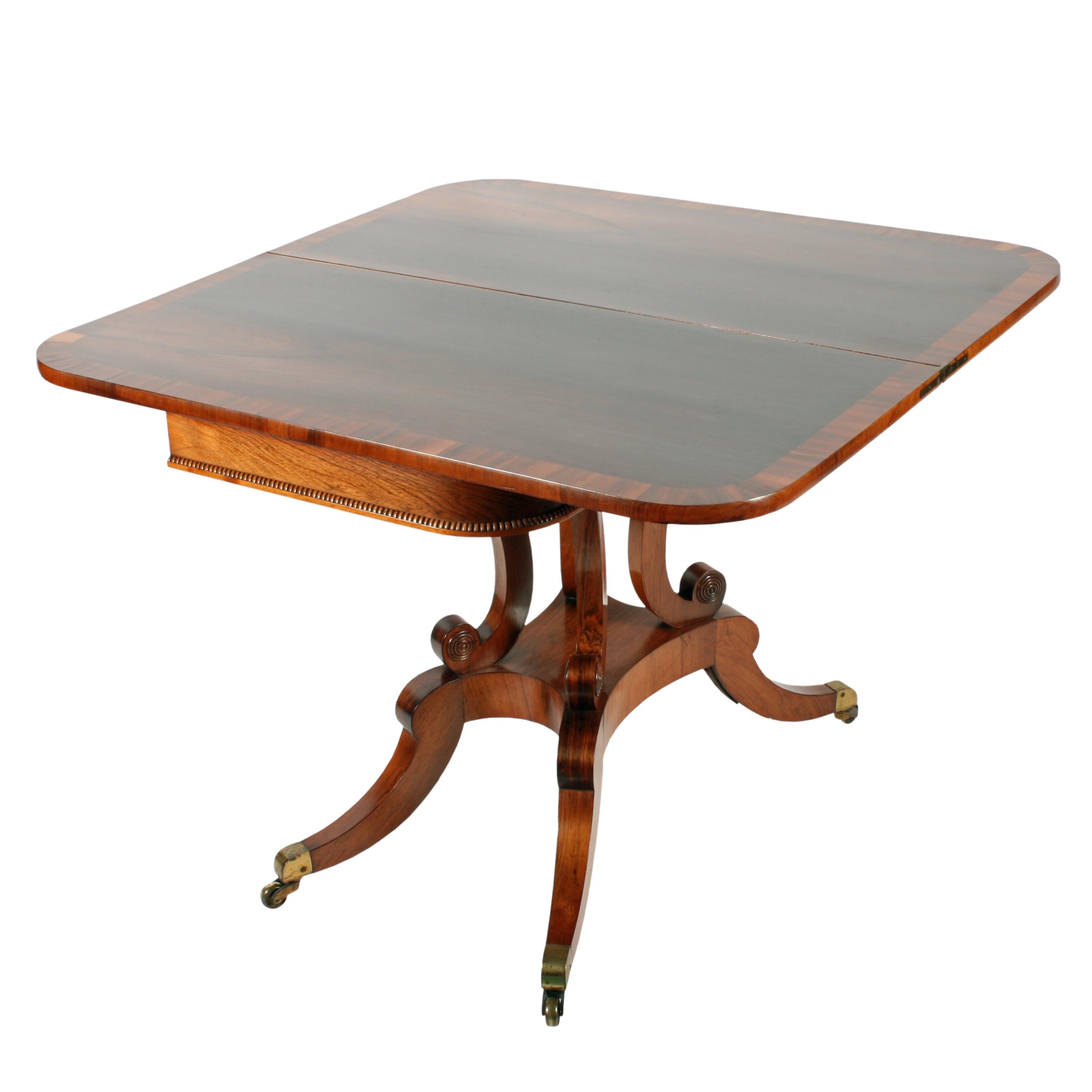 An early 19th century Scottish Regency rosewood turn over top tea table.

The table is in the style of Trotter of Edinburgh, the top and interior have a broad rosewood cross banded edge and a 'Pea' bead along the lower edge of the frieze.

The
