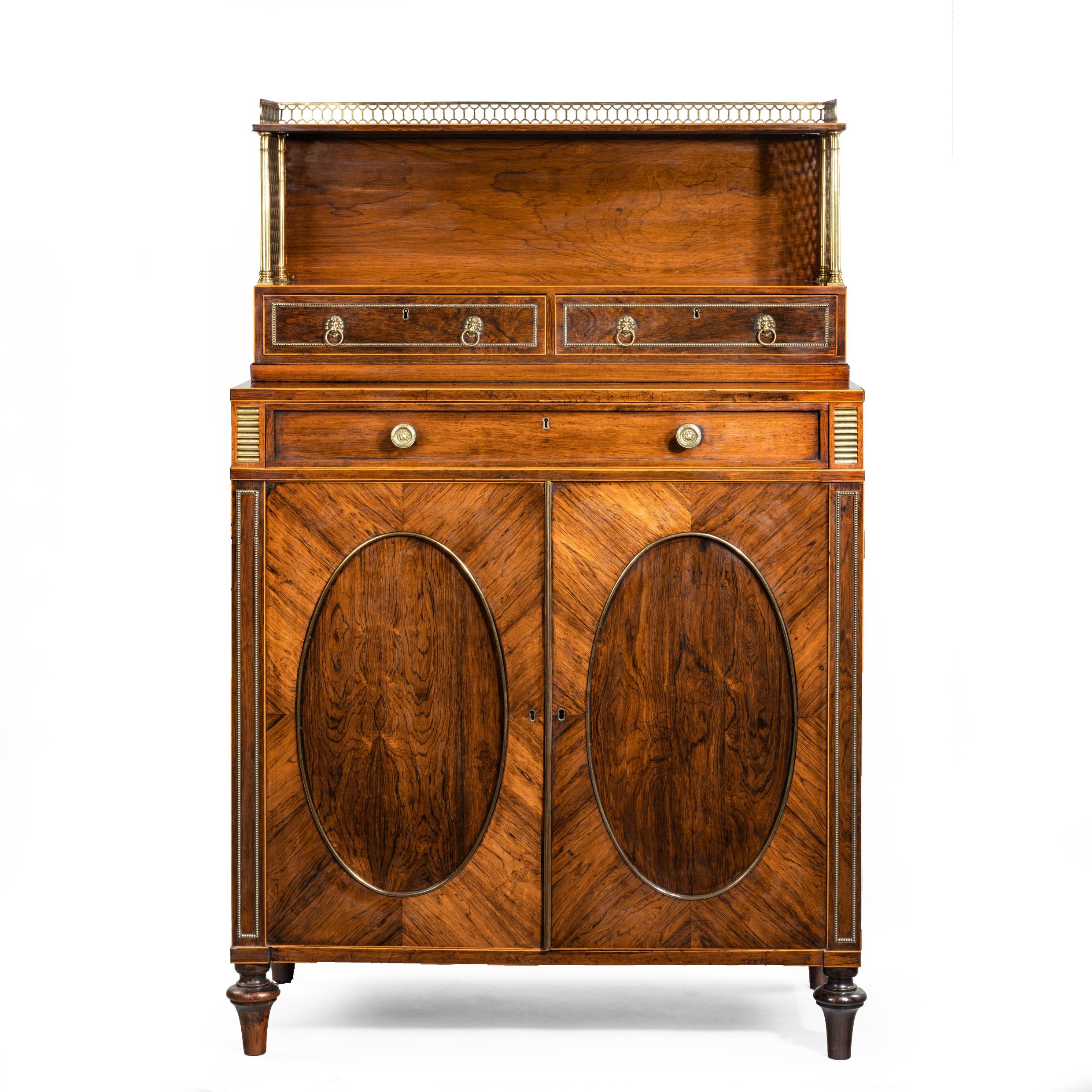 A fine high Regency rosewood two-door side cabinet, attributed to John Mclean, of upright rectangular form, the upper section comprising two small drawers and a bookshelf, the ends enclosed with ormolu trellis, all above a single long drawer and a