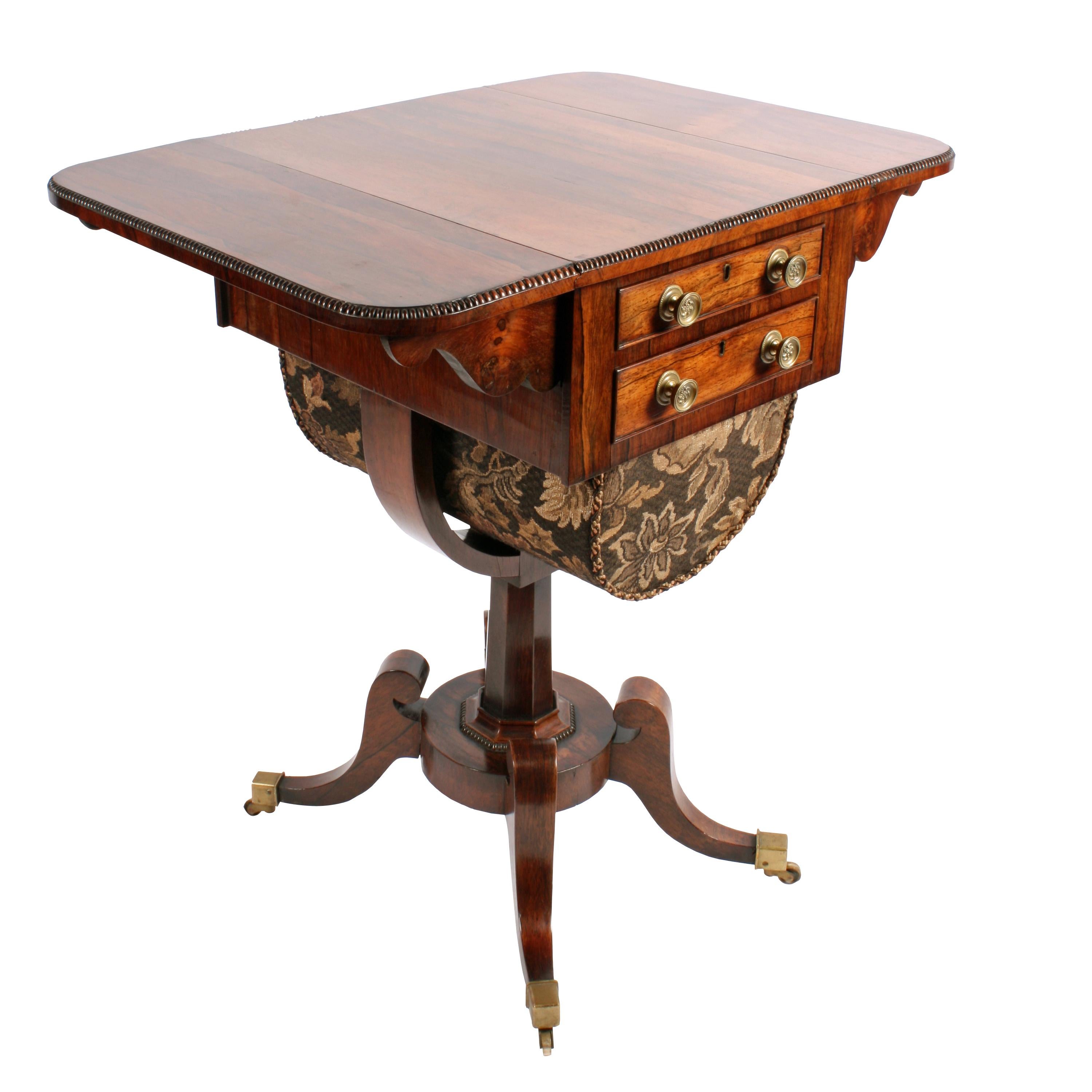 An early 19th century Regency rosewood drop-leaf lady's work or sowing table.

The table has an oblong top with a beaded edge and two drop leaves that have a pair of shaped rosewood supports for each.

The pair of drawers have a cock bead edge,