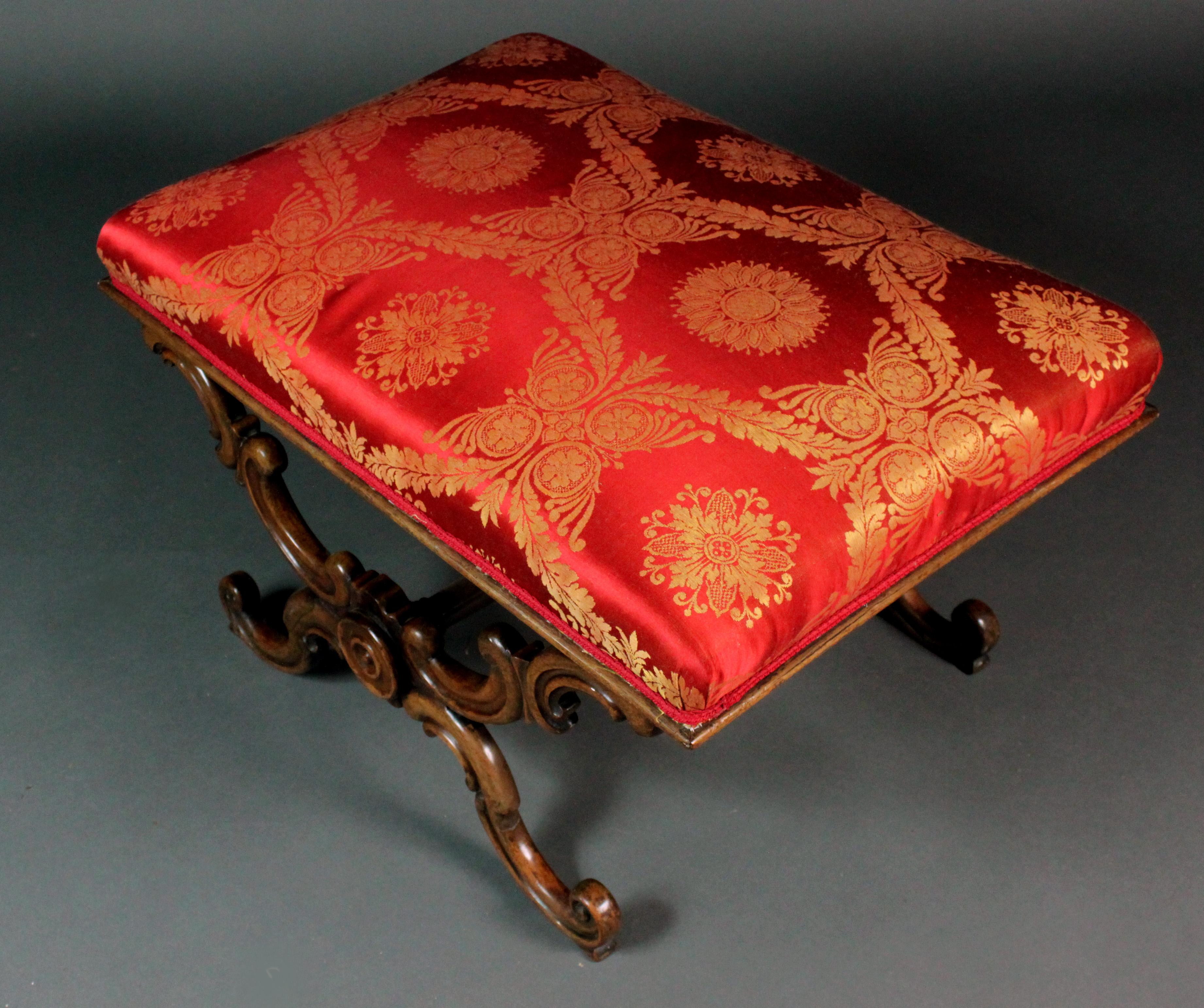 A large late Regency / Early Victorian rosewood X stool of a good original colour and patina: Rococo design with finely carved c-scrolls and handsome turned and carved central stretcher. Recently re-covered in fine red and gold silk.
Good and