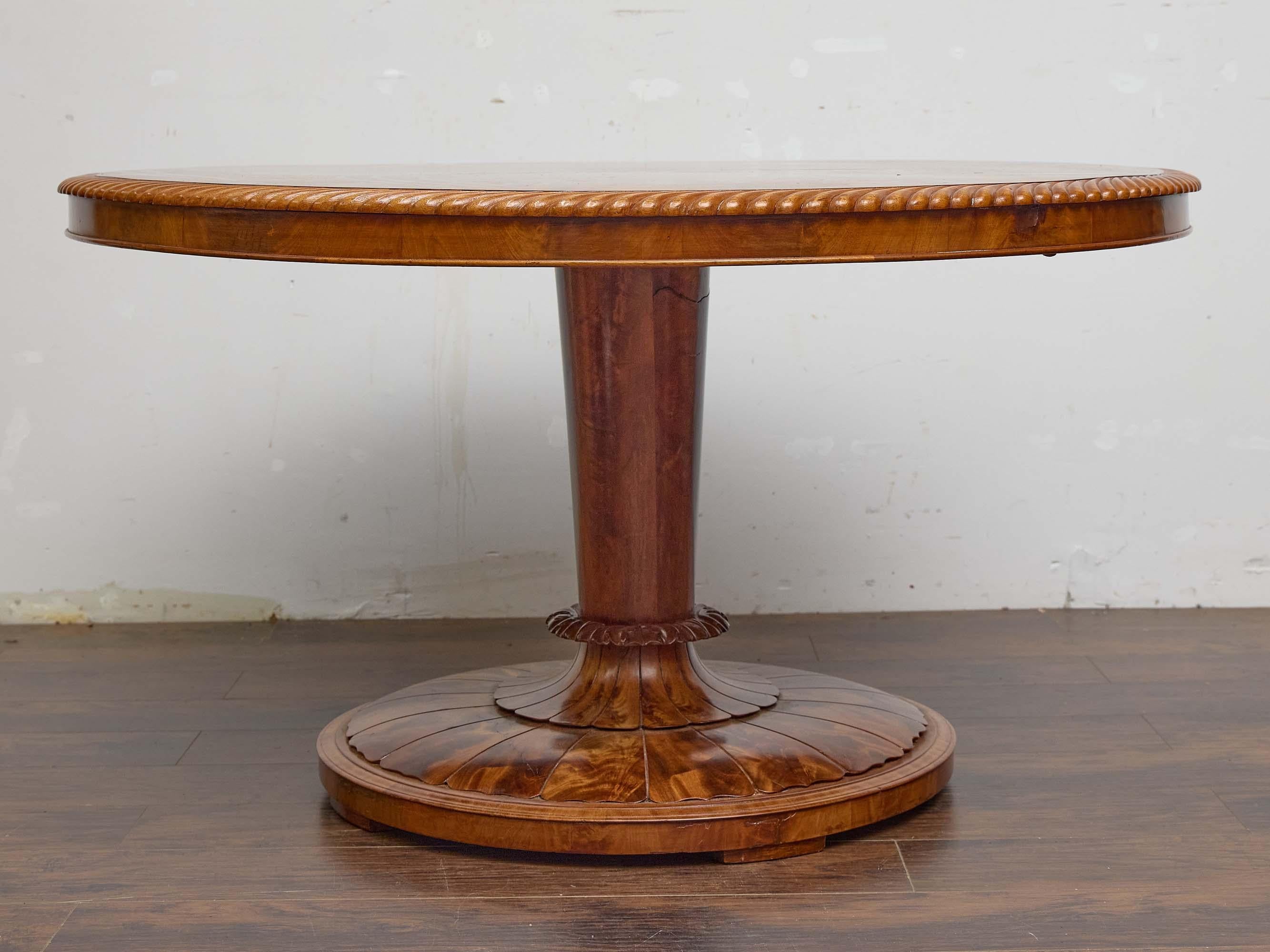 Dieser englische Regency-Mitteltisch, der um 1840 gefertigt wurde, zeigt die raffinierte Eleganz und das symmetrische Gleichgewicht, die für diese Zeit charakteristisch sind. Die runde Platte aus wunderschön gemasertem Nussbaumholz weist ein