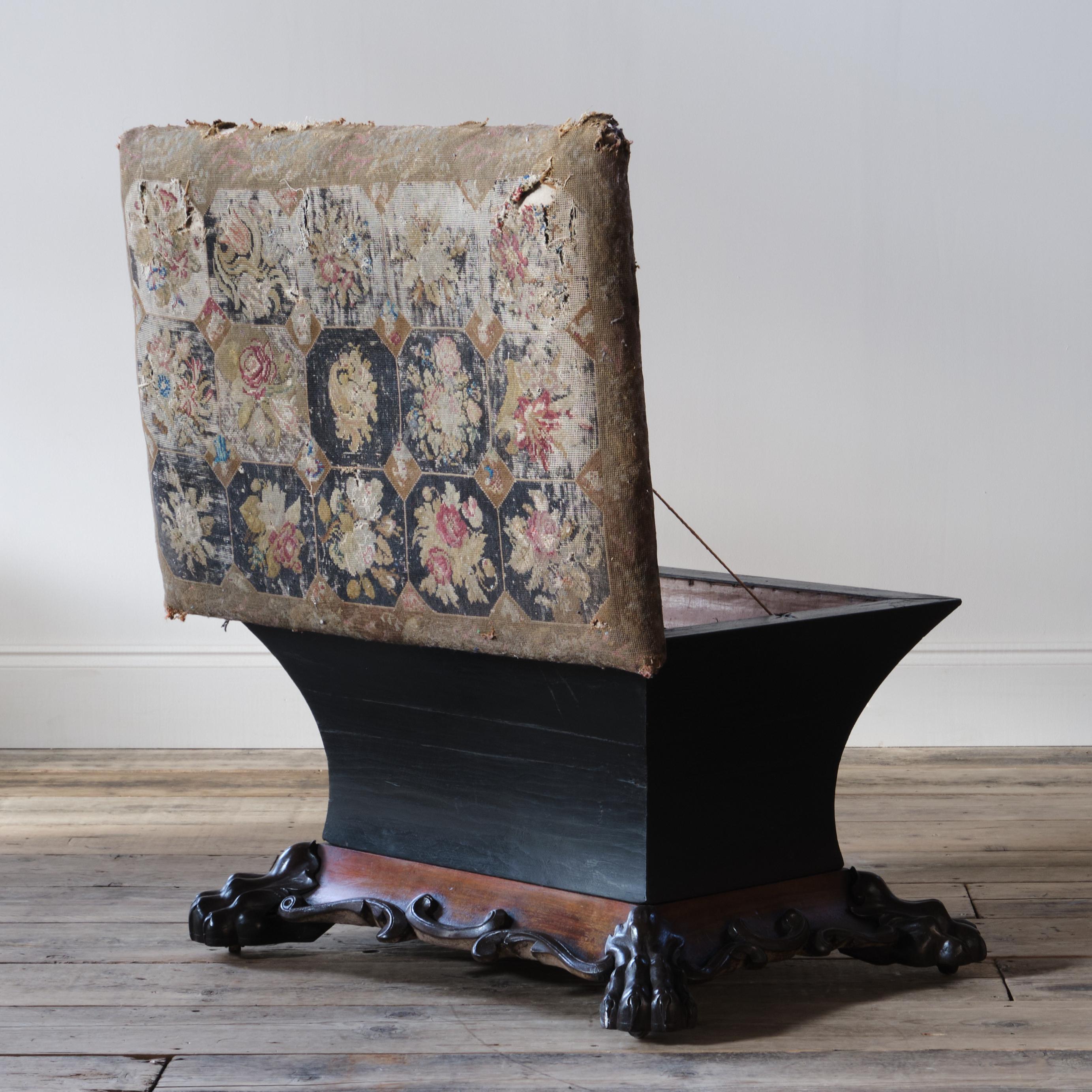 A superb early 19th century Regency country house sarcophagus box ottoman constructed with an ebonized pine box and raised on crisply carved mahogany paw feet and al with the original brass recessed casters. 

The original tapestry upholstery is in