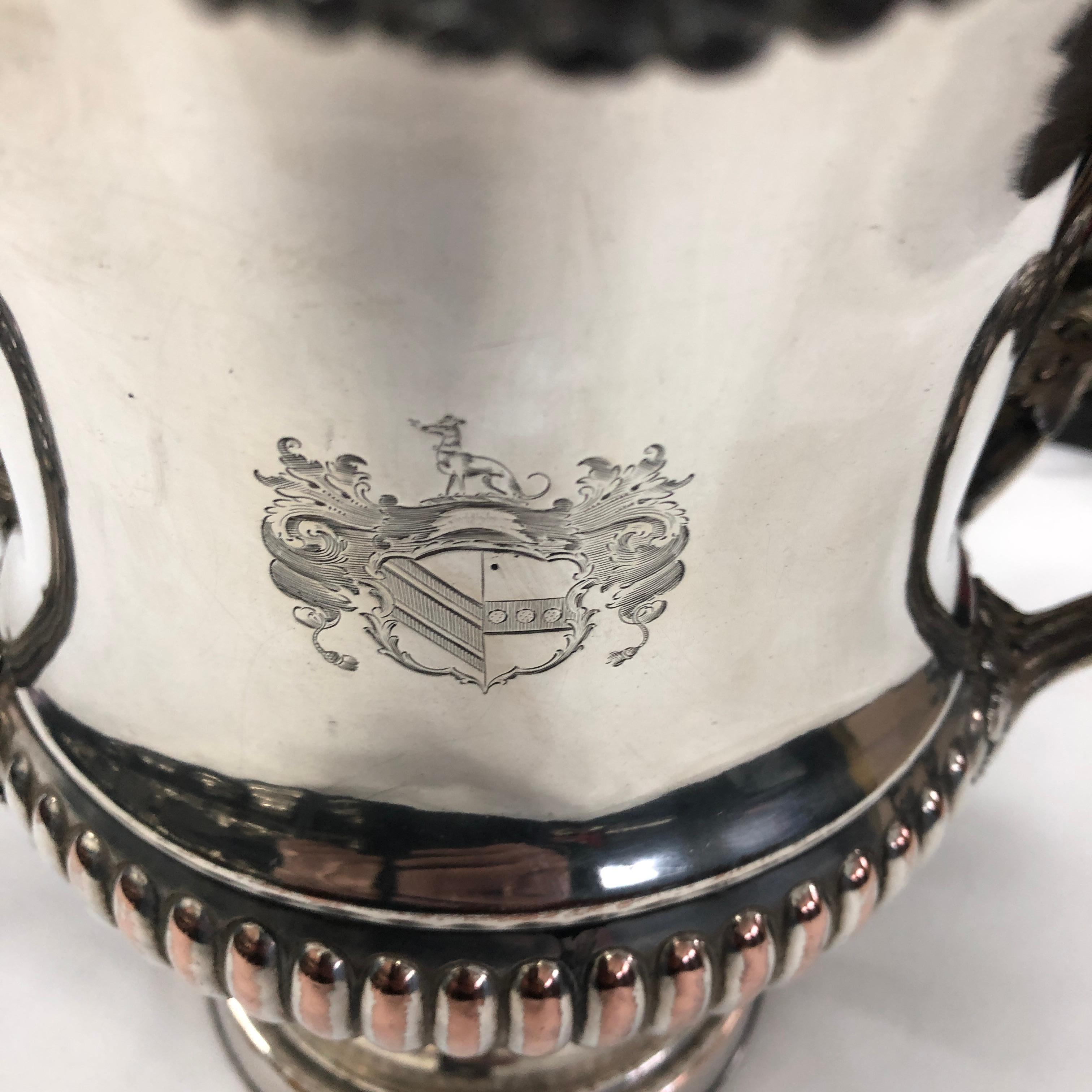 It's a Sheffield plate wine cooler in the style of Matthew Boulton, the signs of age create an amazing antique look. Owner crest in the front and a W on the bottom.