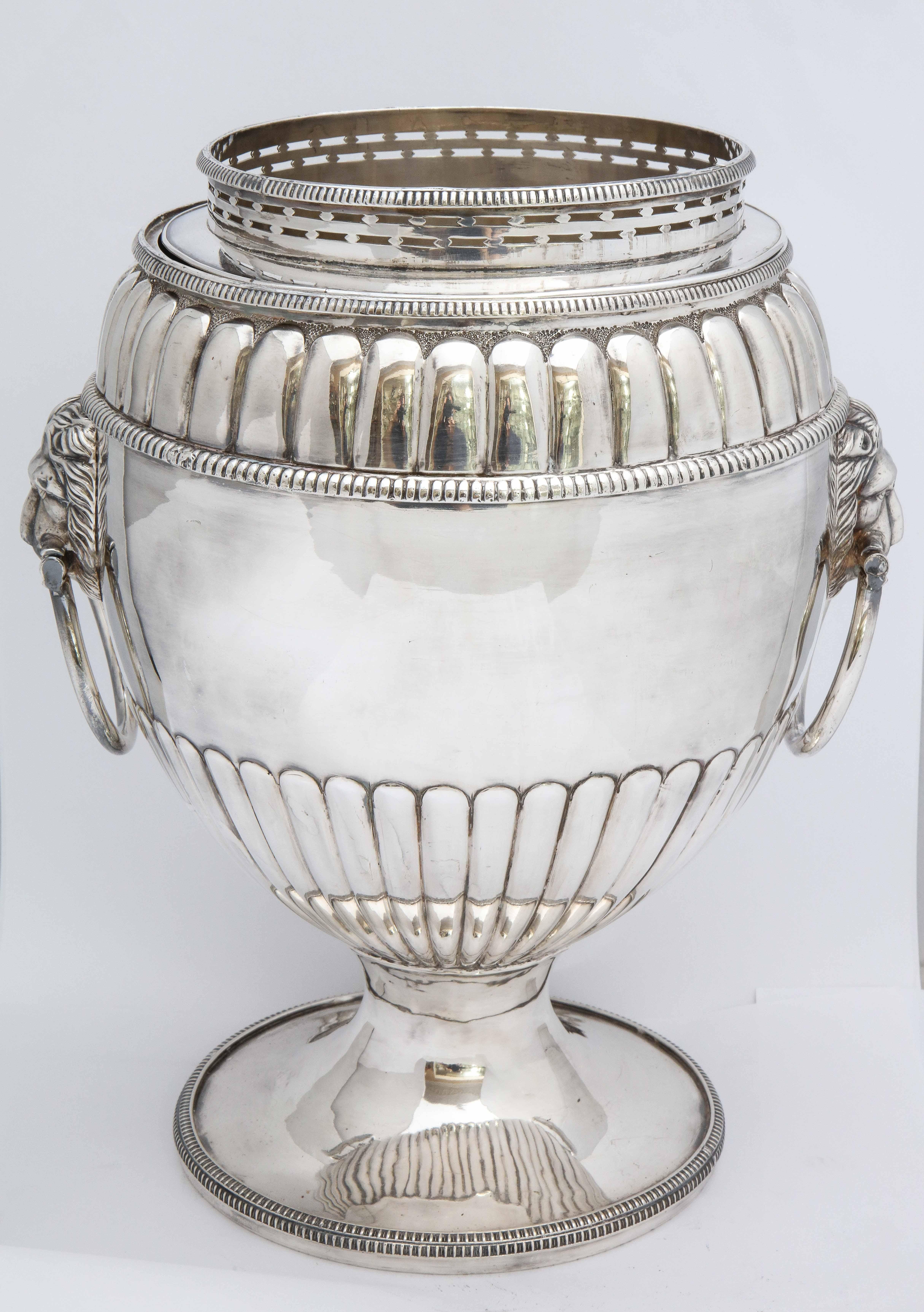 Regency, Sheffield plated, pedestal based wine cooler, England, Ca. 1840's. Has lion's head handles, with each lion having a movable ring in its mouth. Cooler has original insert and removable collar. Fluted design; vacant cartouche. Rim is very