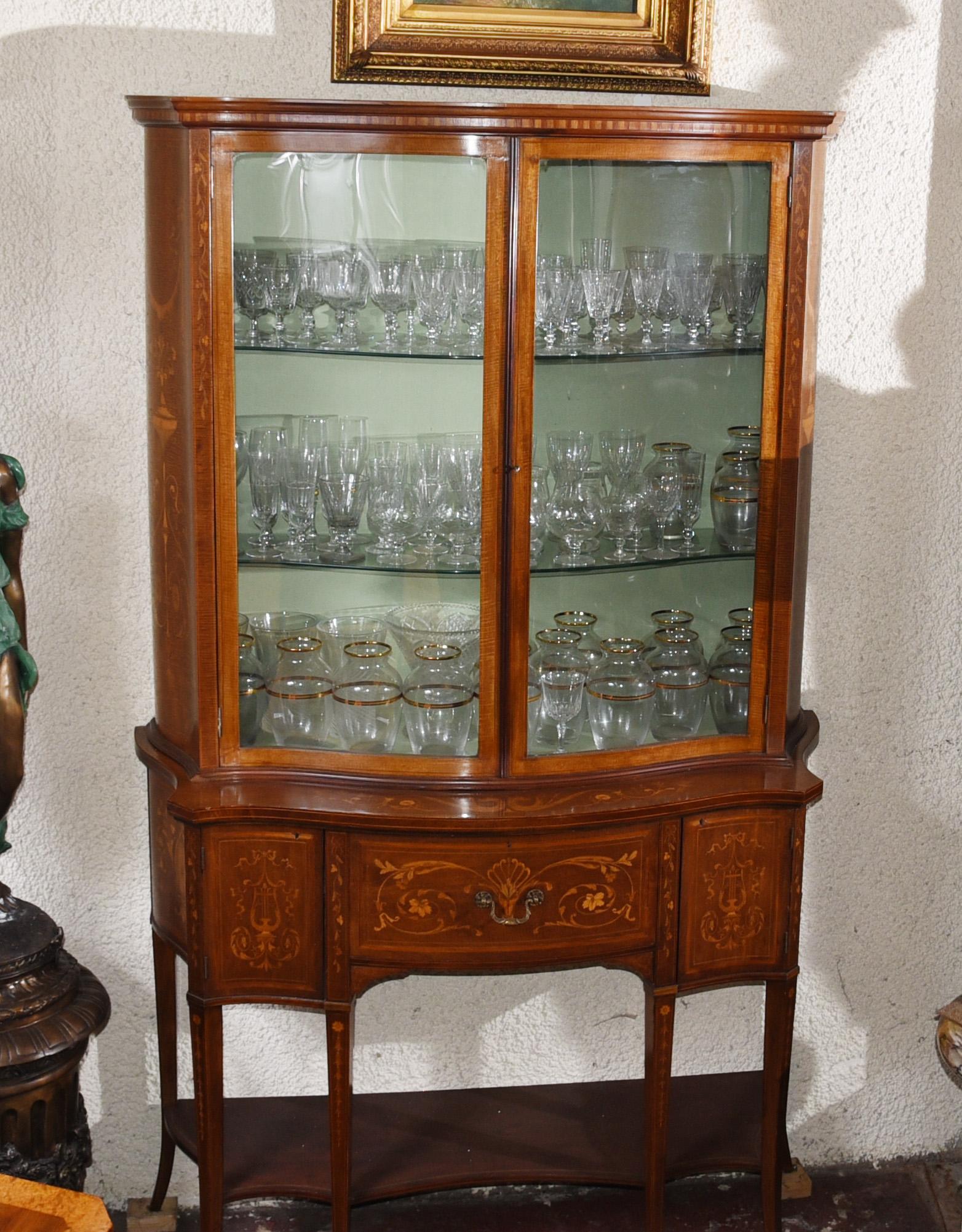 Gorgeous Regency Sheraton style display cabinet / bookcase
Serpentine form to the front
Great for displaying decorative pieces such as glass and porcelain
Intricate inlay work includes floral motifs and urn motifs
Offered in great shape ready for
