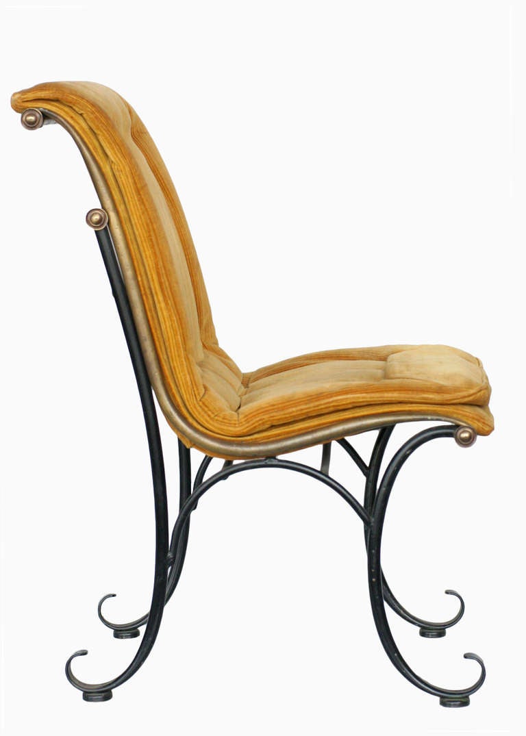 Elegant ensemble de quatre chaises d'appoint en fer de style Regency du milieu du siècle dernier, avec des accents de volutes en bronze, dans une forme dynamique curviligne et des coussins en velours doré touffeté.

