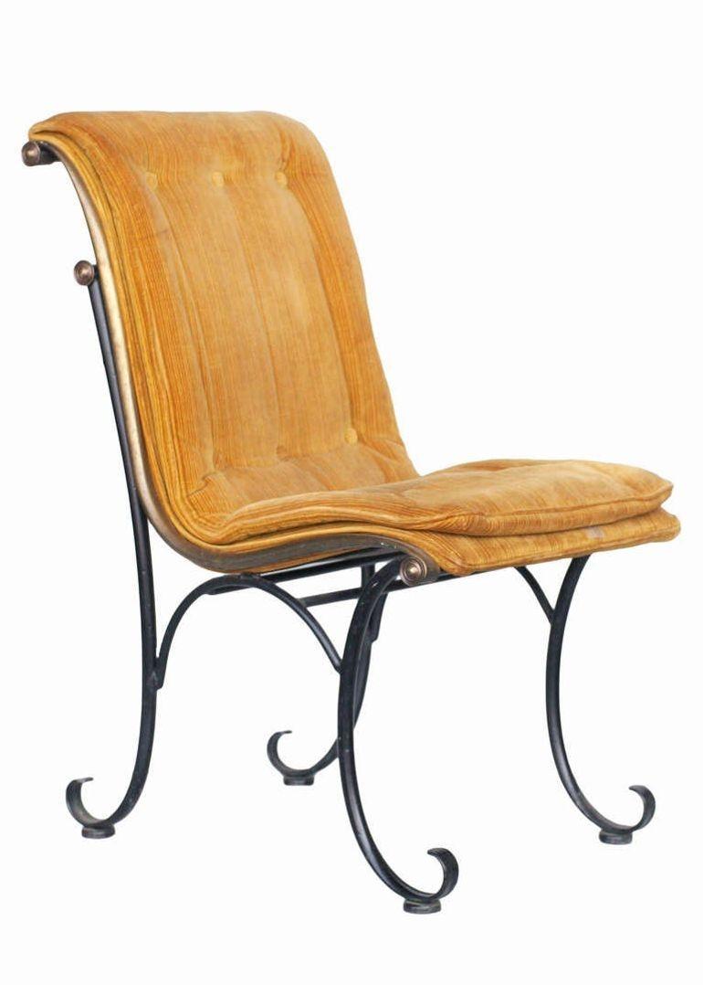 Elegant Mid-century set of four iron Hollywood Regency/Mid-century style side chairs with bronze scrollwork accents, in curvilinear dynamic form and tufted gold velvet cushions. These chairs were featured in many Hollywood films and homes during the