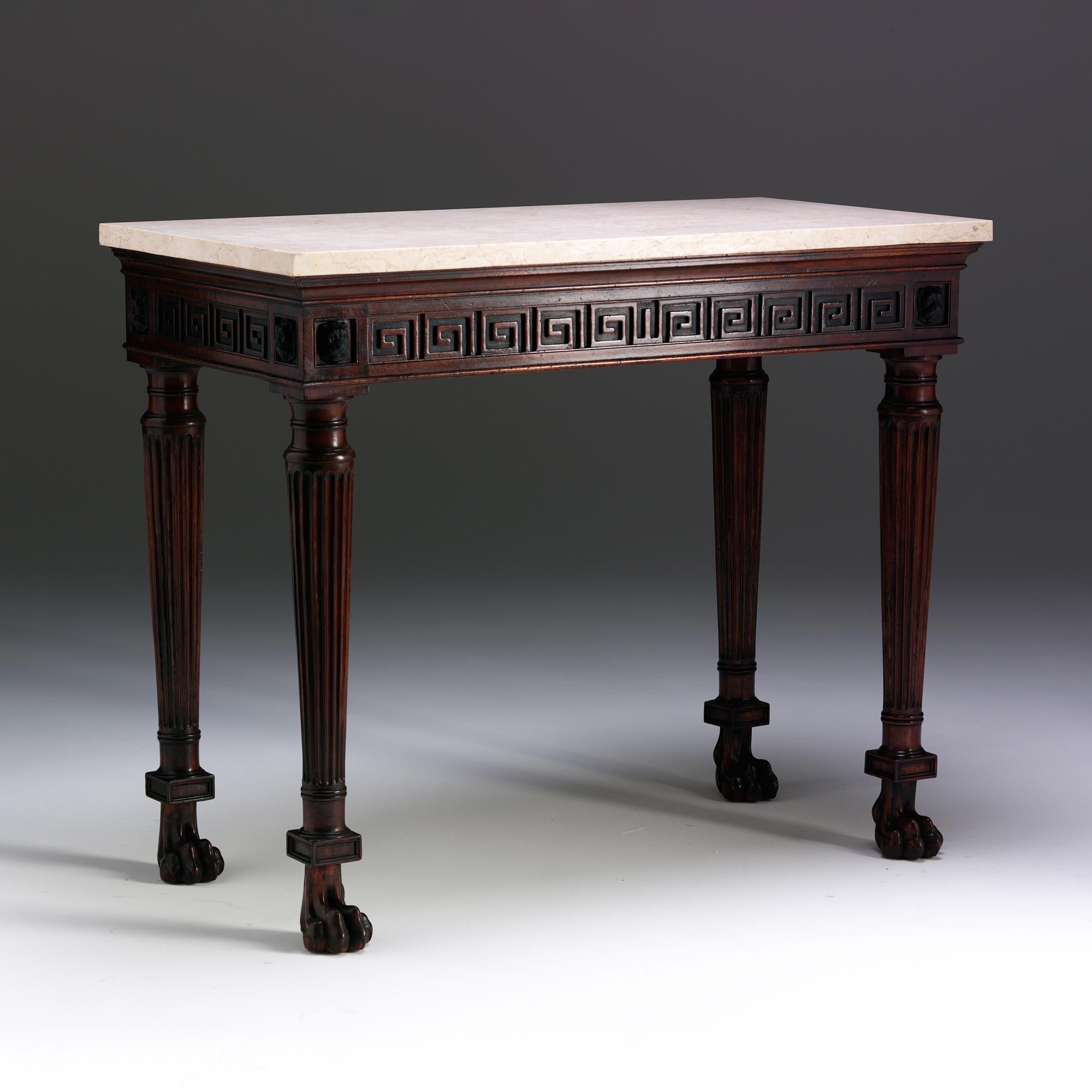 This console table displays the best classical inspiration of the Regency period. In this example the white marble top sits above a moulded frieze carved with Greek key patterned blind fretwork flanked by carved leopard head masks. The tapered and