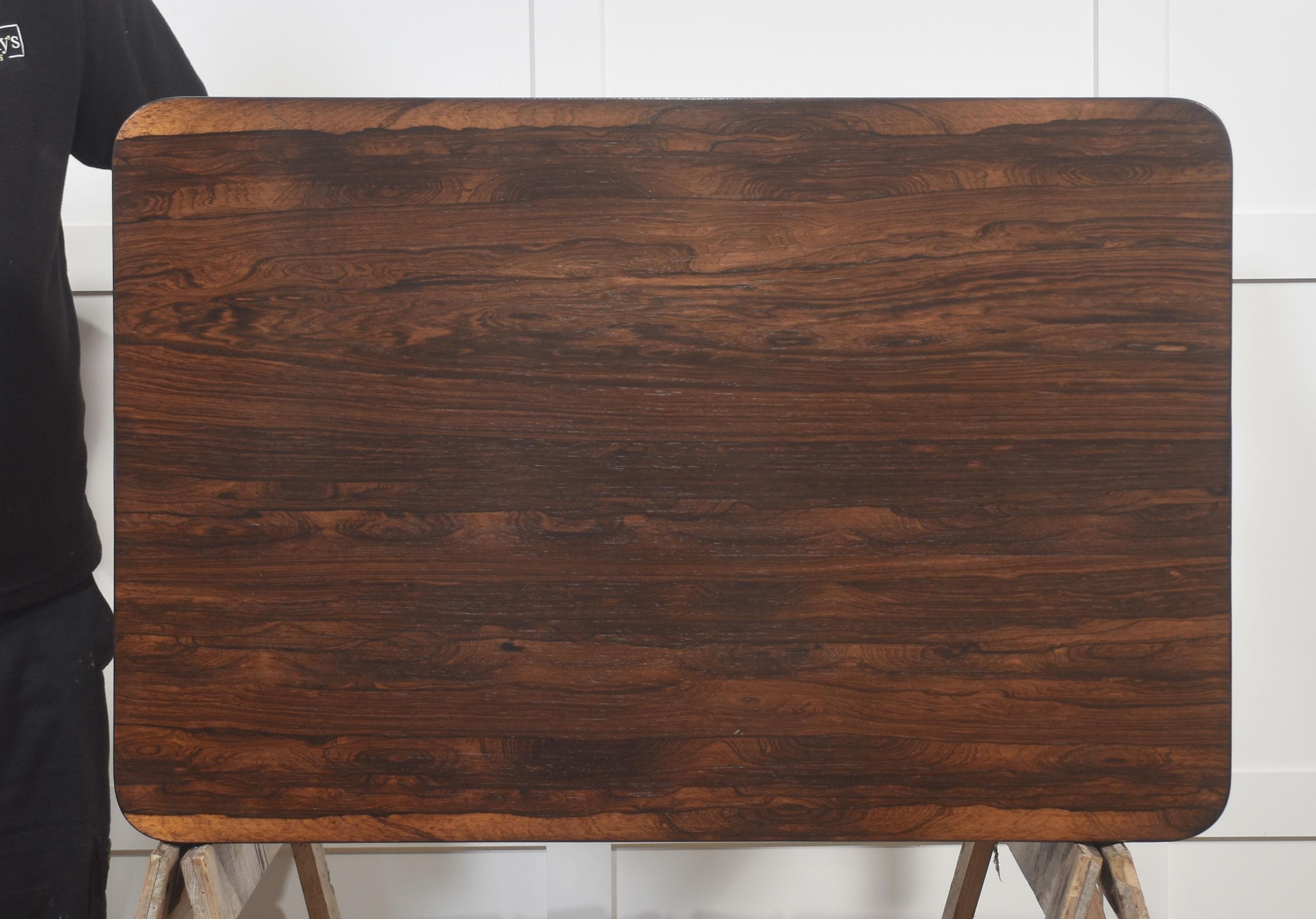  Una llamativa mesa auxiliar o de recibidor de palisandro de la época de la Regencia, de excepcional calidad y elegante diseño. La tapa rectangular, bellamente labrada, con esquinas suavemente redondeadas, muestra el rico veteado y la lustrosa