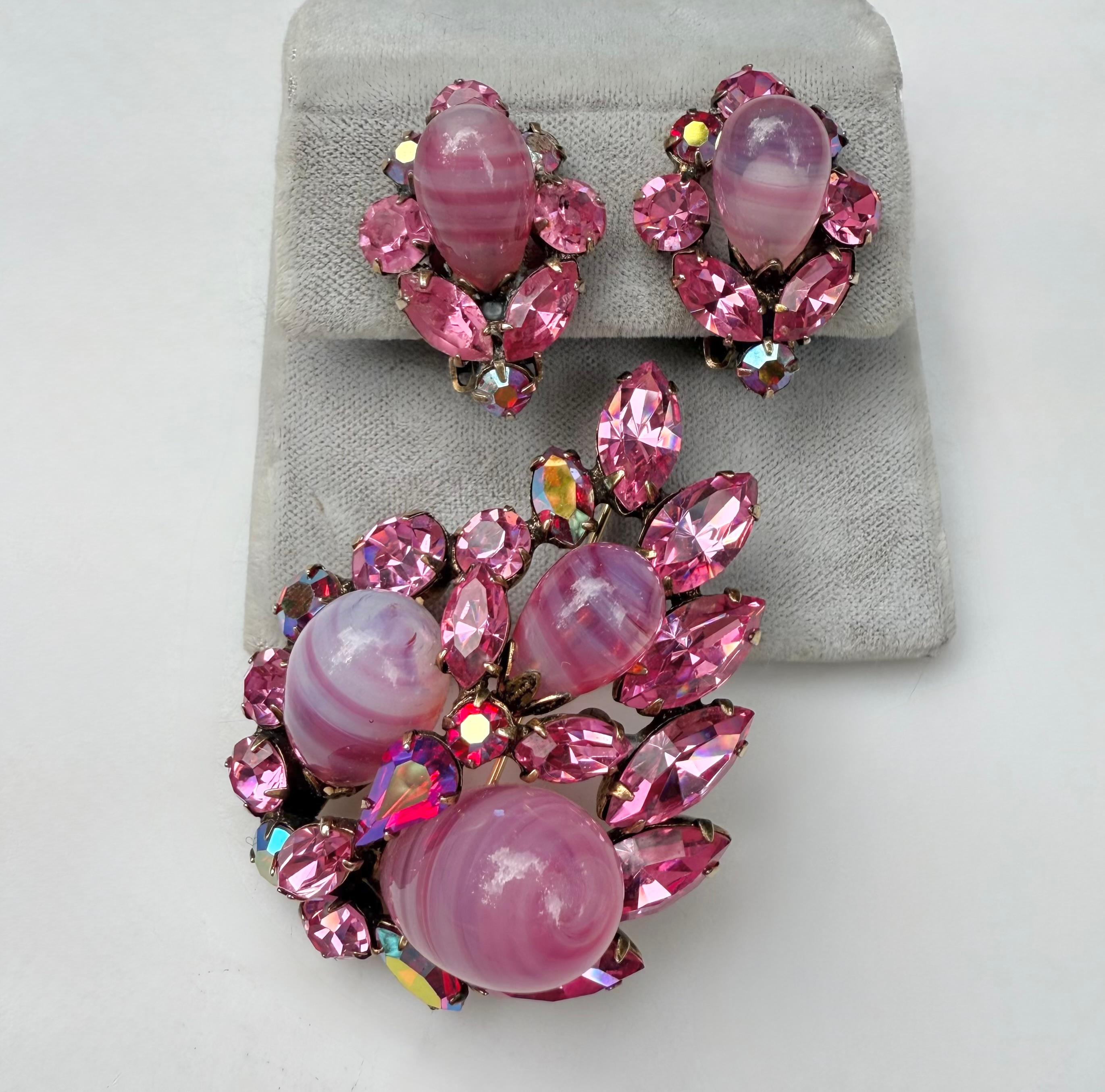 Brilliant jewelry set by Regency includes a coordinating brooch and earrings, embodying the brand's signature style. The brooch features three pear-shaped pink swirled art glass stones surrounded by vibrant pink navette crystals, all set on a rich