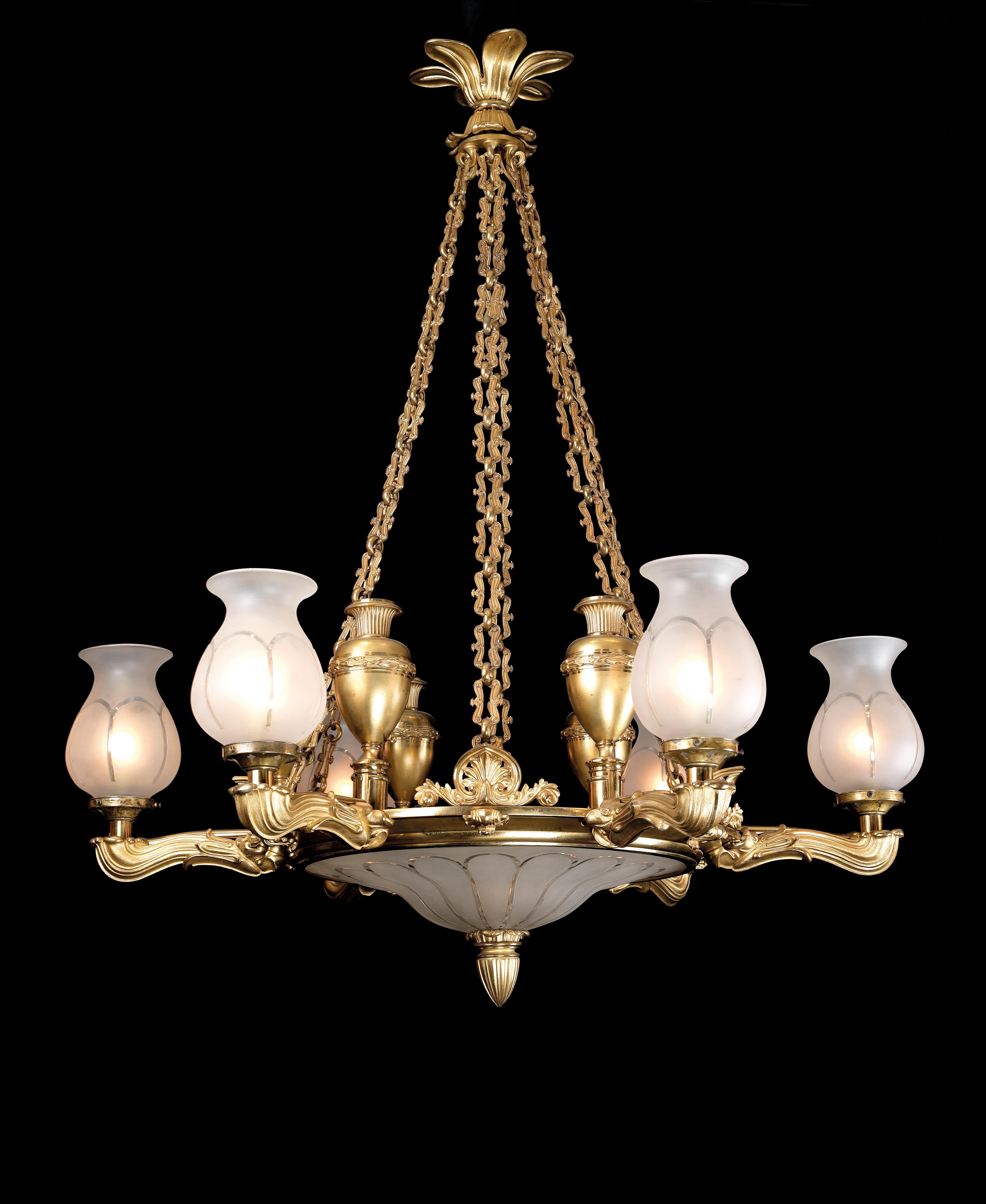 A Regency six-light gilt-bronze chandelier by Hancock & Co.

English, circa 1830. 

A Regency six-light gilt-bronze chandelier by Hancock & Co with a lotus leaf ceiling corona supporting a frosted and cut glass dish on six chains, the lotus cast