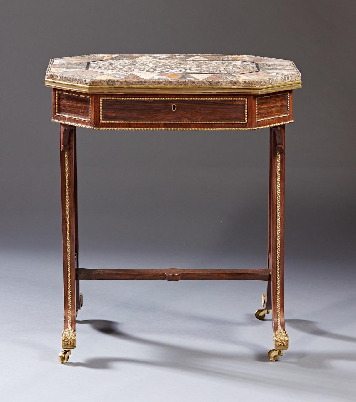 A rare side table attributed to Gillows of London and Lancaster having a specimen inlaid marble top rests on a conforming octagonal shaped case in rosewood with a single drawer on down swept legs. The entire case and legs are mounted with gilt