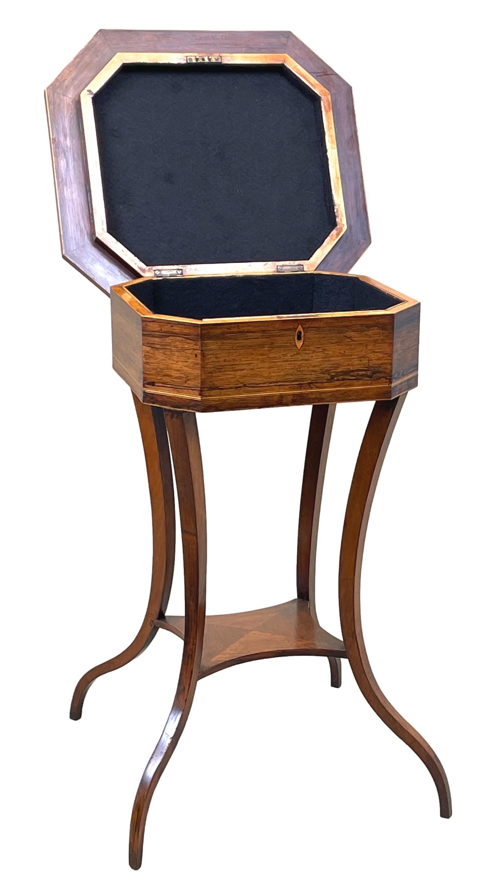 An extremely good quality regency period rosewood work table, of octagonal form, having charming specimen wood parquetry inlaid top, enclosing baized interior compartment, raised on four elegant, extravagantly swept legs united by Central
