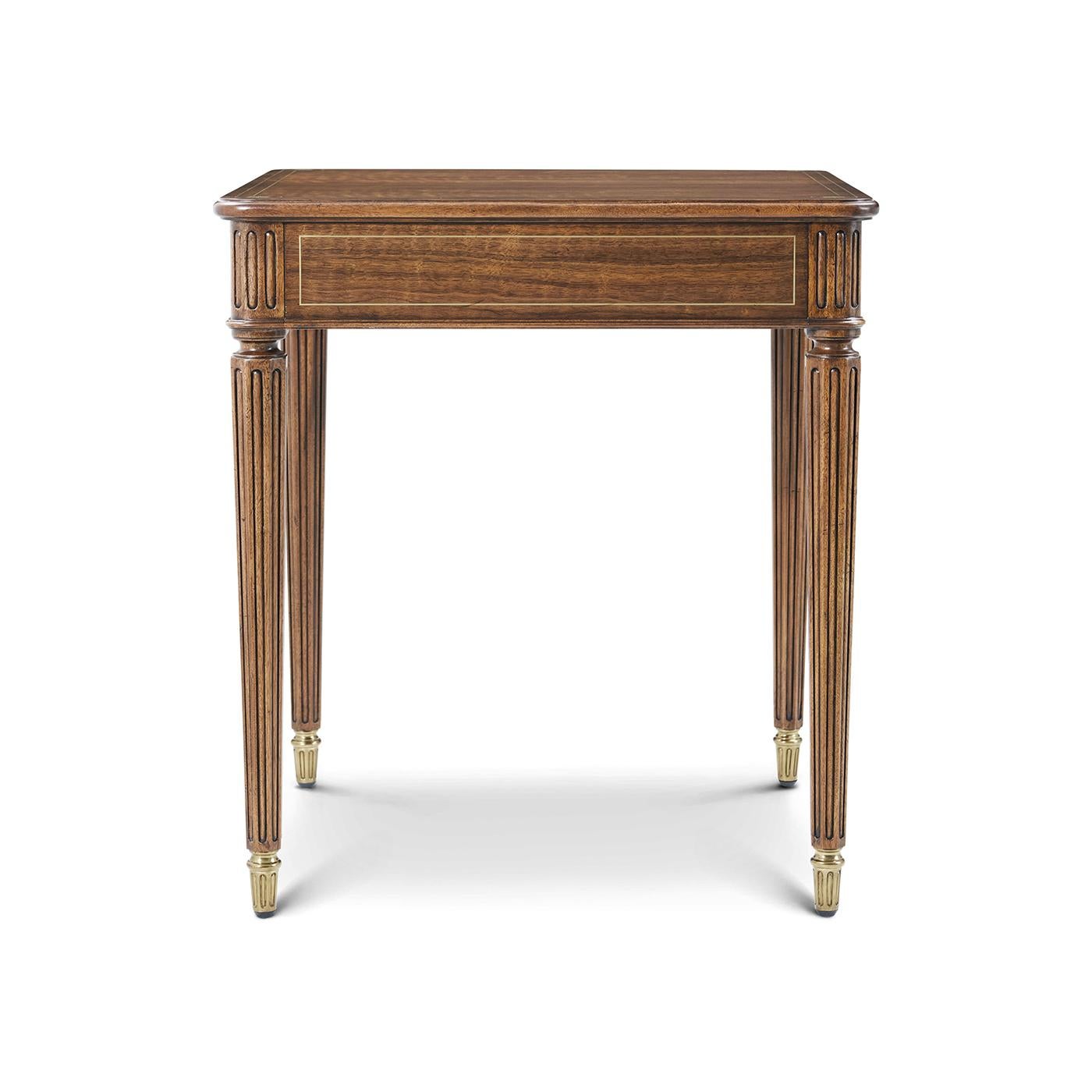 Handcrafted in figured walnut and inspired by classic English designs. Its square top, with a rich Heirloom finish, is subtly elevated by brass inlay detailing that underscores its refined silhouette. Tapered, reeded legs capped in brass ferrules