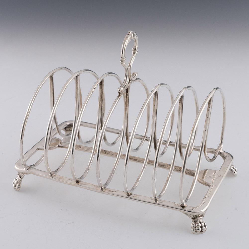 Titolo: Porta toast in argento con sei divisioni
Data : Punzonato a Londra nel 1818 per William Sumner
Periodo: Reggenza / Giorgio III
Origine: Londra, Inghilterra
Decorazione: sei divisioni con divisori a doppio anello. Manico ad anello con volute