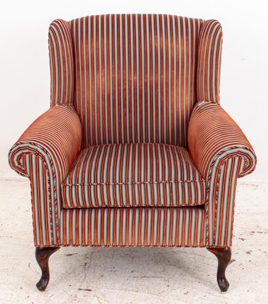 Regency stripe voided velvet upholstered wing chair of typical form, with garnet velvet stripe on, blue and buff striped ground, the chair with drop in seat cushion on four square legs. 

Dimensions: 41