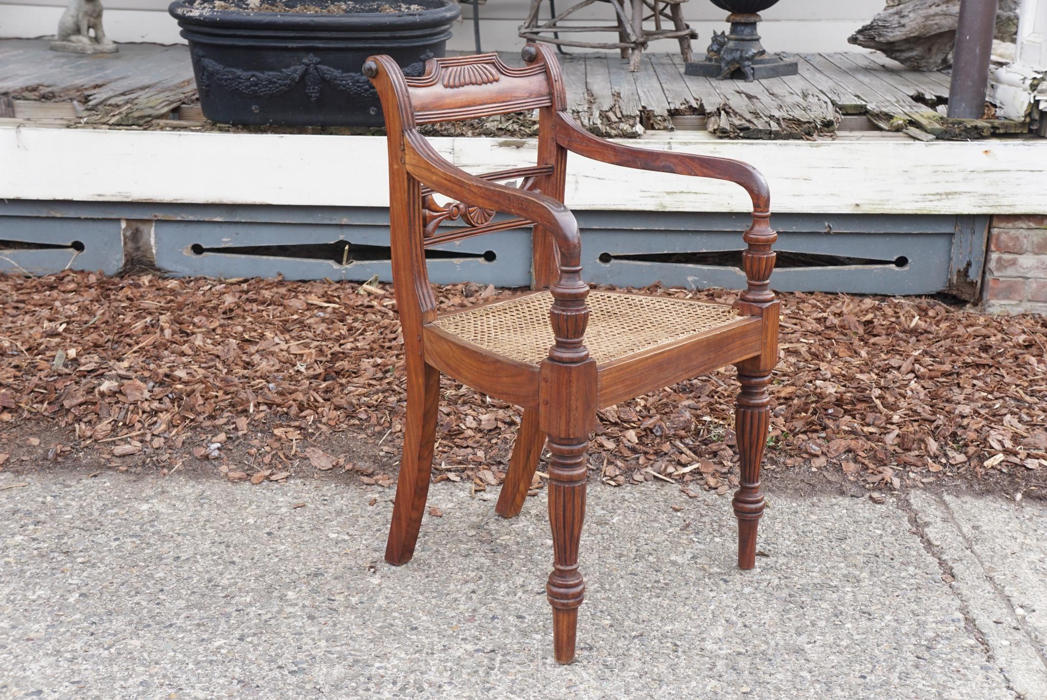 A good set of 10 vintage Anglo-Indian rosewood chairs in the Regency style made circa 1960. The set consists of 8 arms and two sides. Carved from solid indigenous rosewood the chairs are heavy and well made using the time-honored methods of pegged